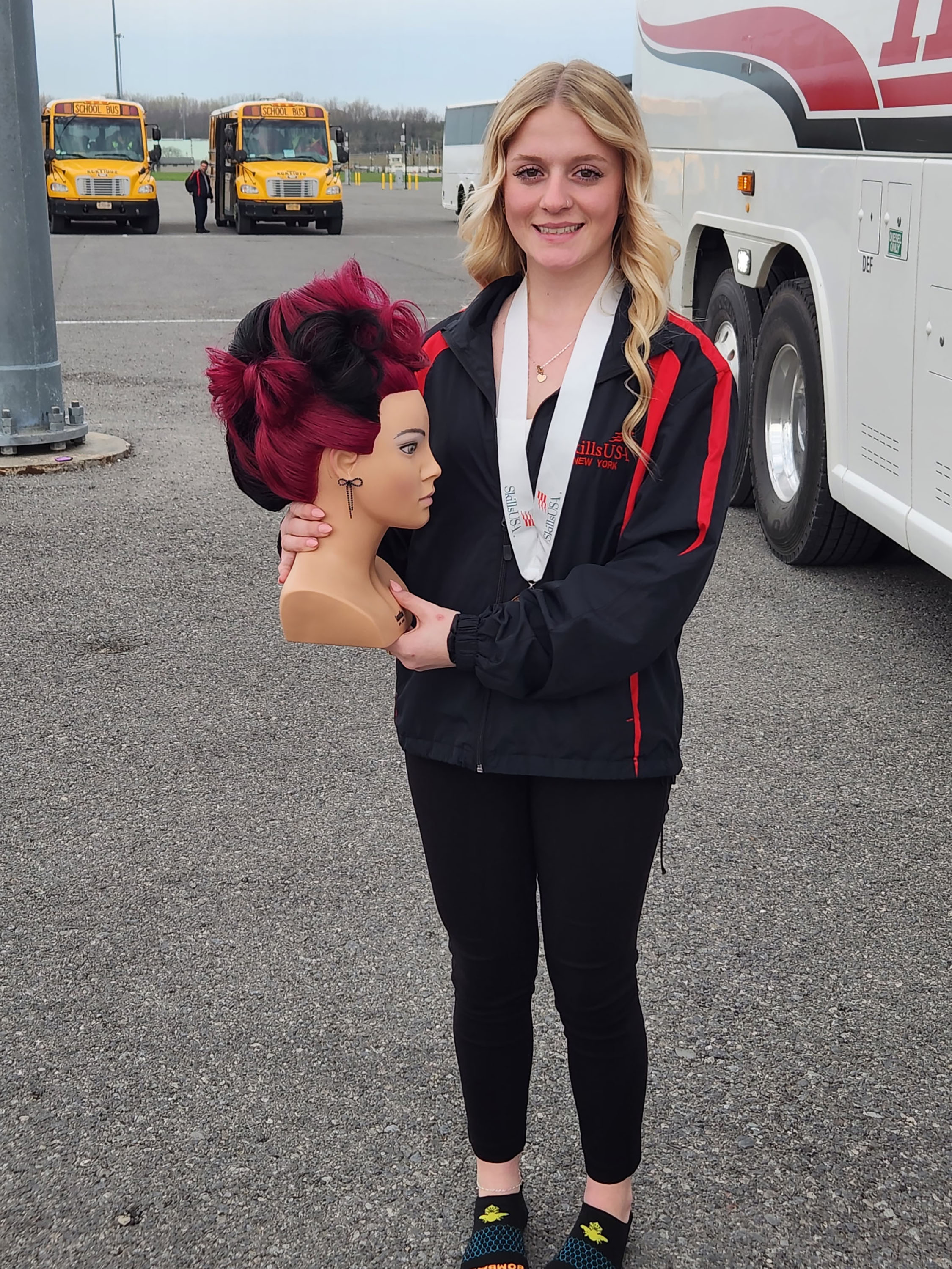 Student with mannequin head and SkillsUSA state medal