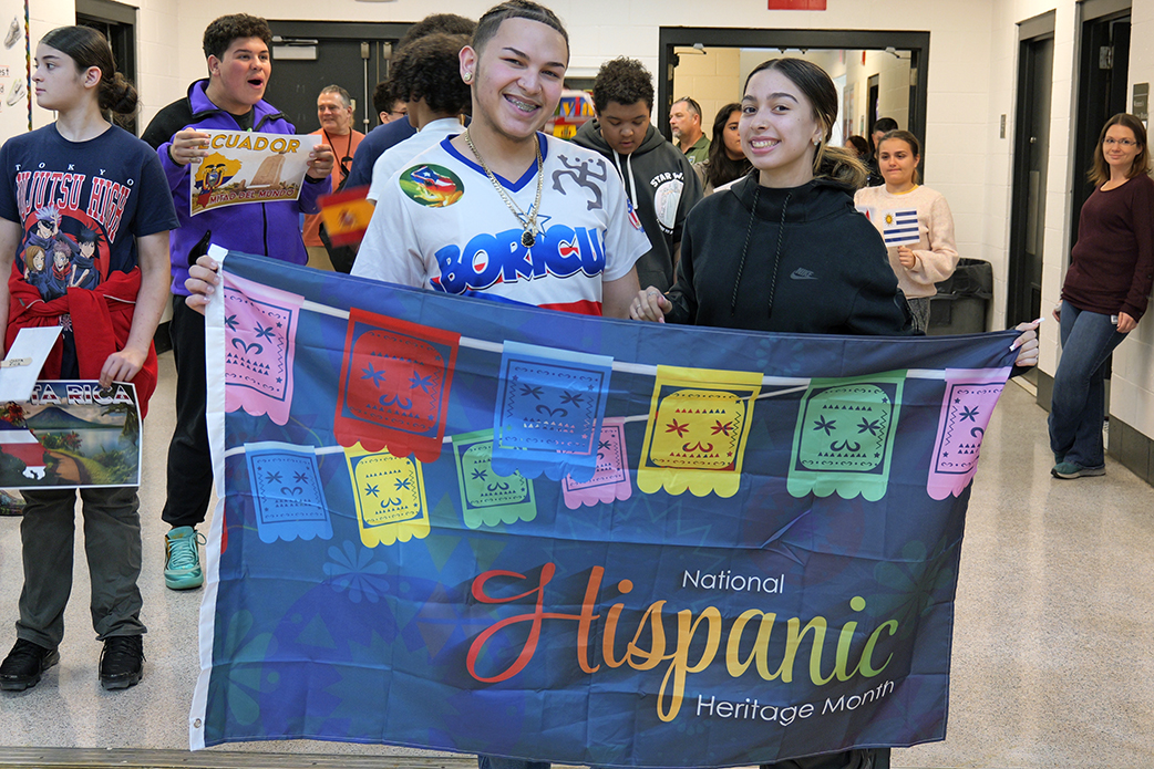Students holding National Hispanic Heritage Month flag