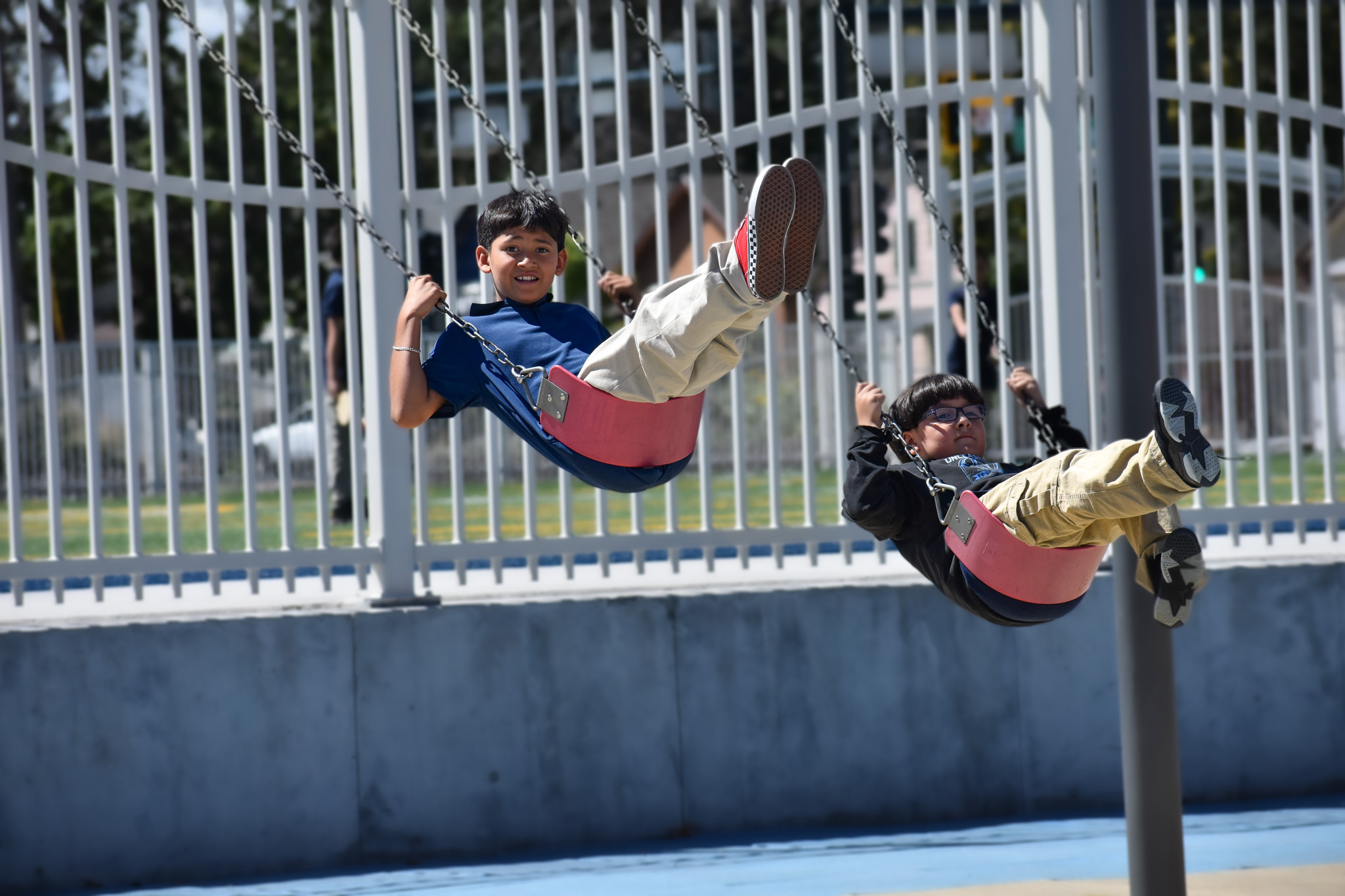 A student smiles while on a swing at recess.