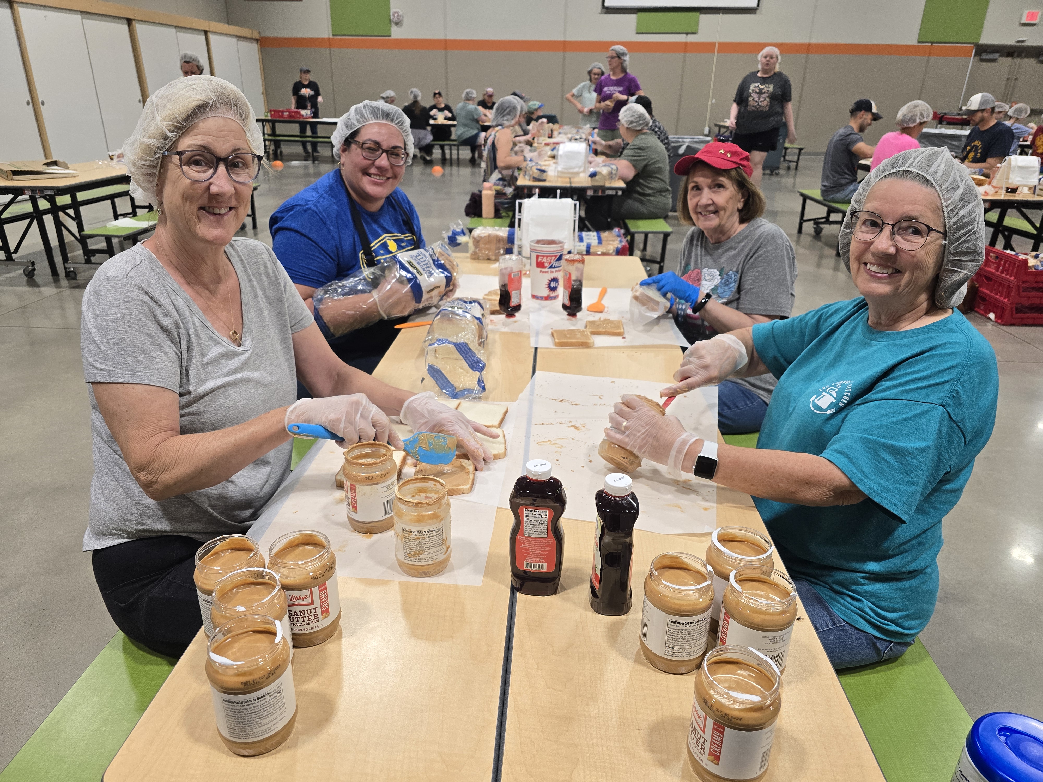 Staff members building peanut butter and jelly sandwiches
