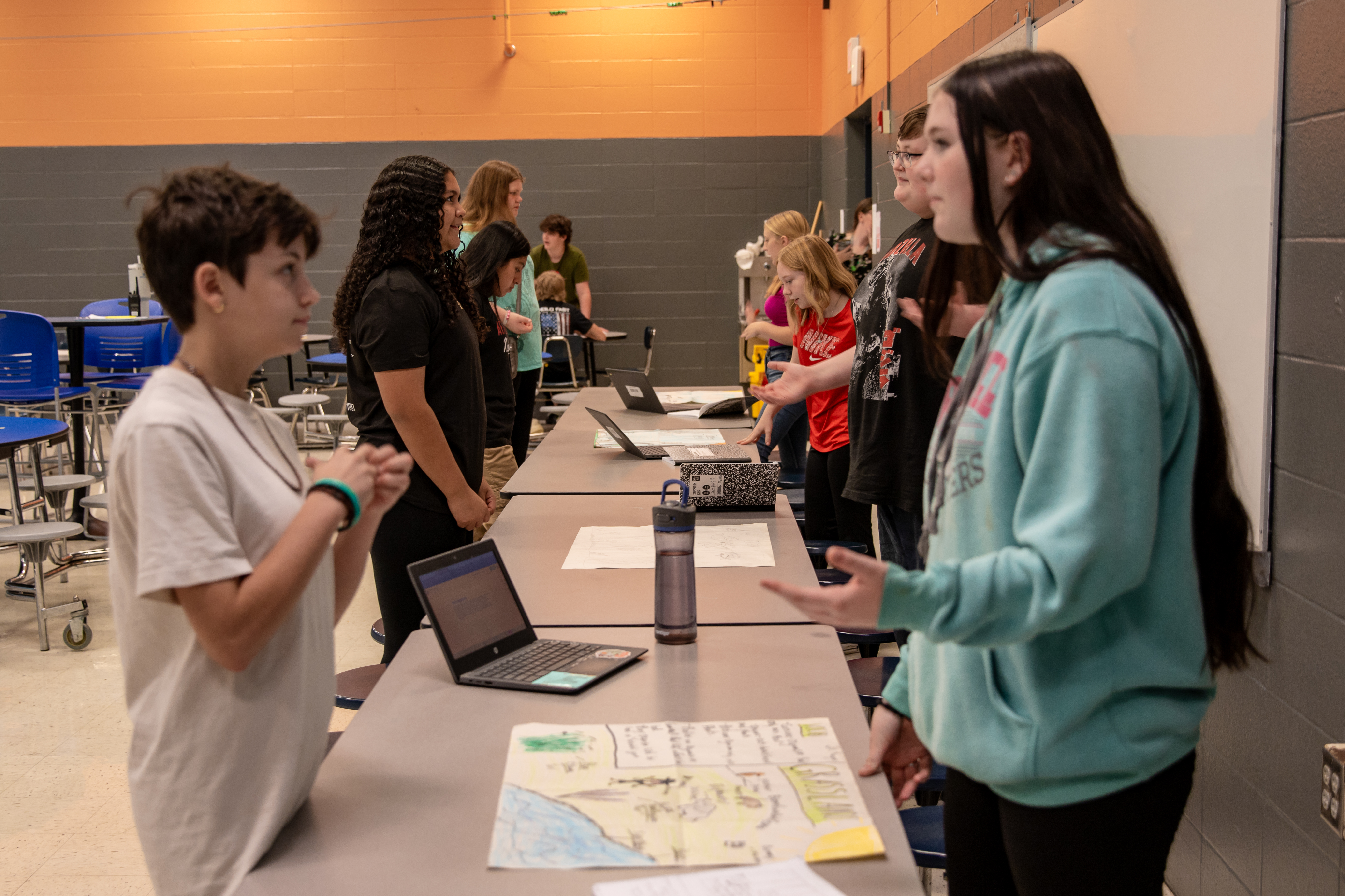 students sharing their learning with posters and computers