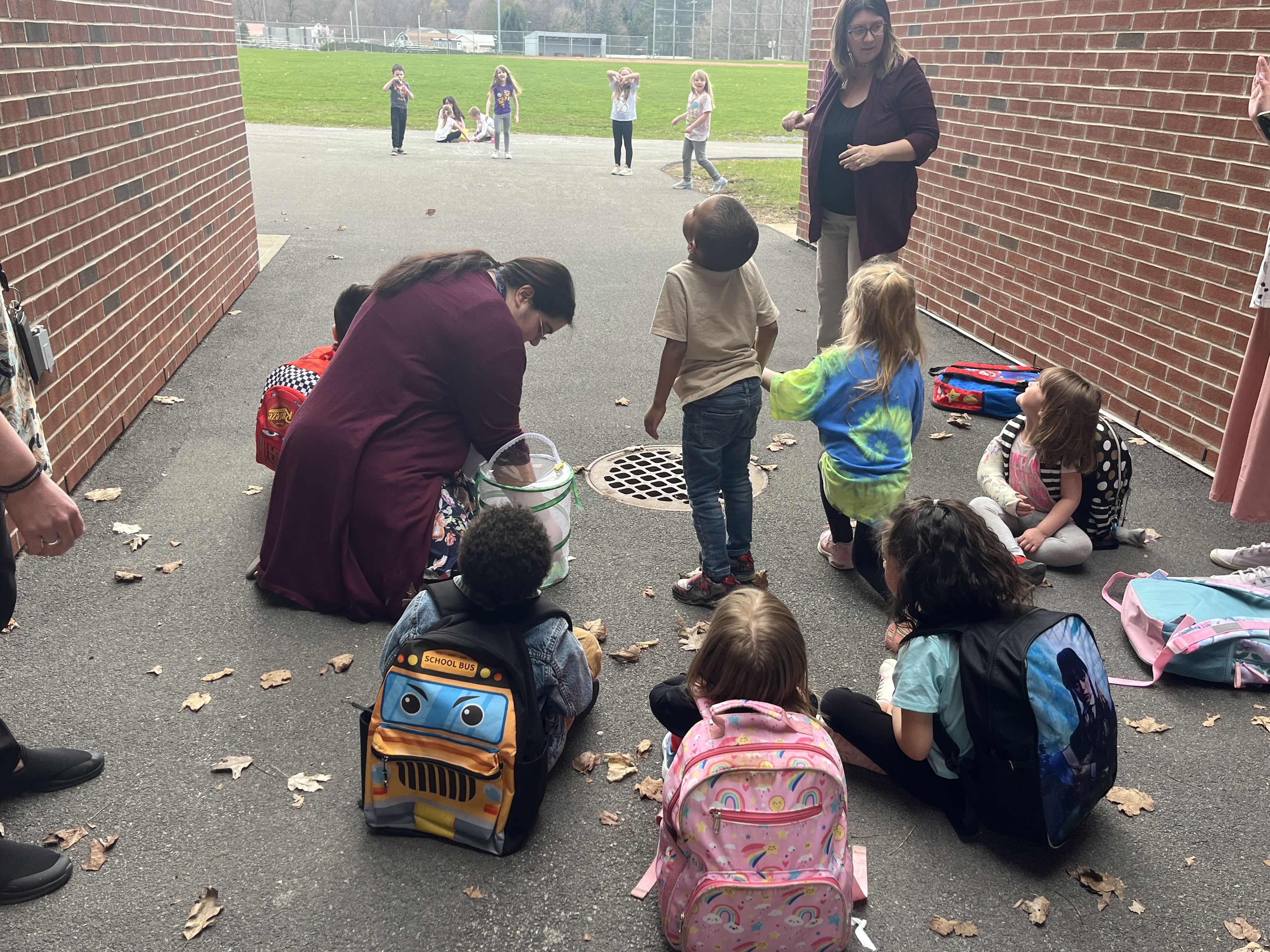 Couple of staff members and several students releasing butterflies