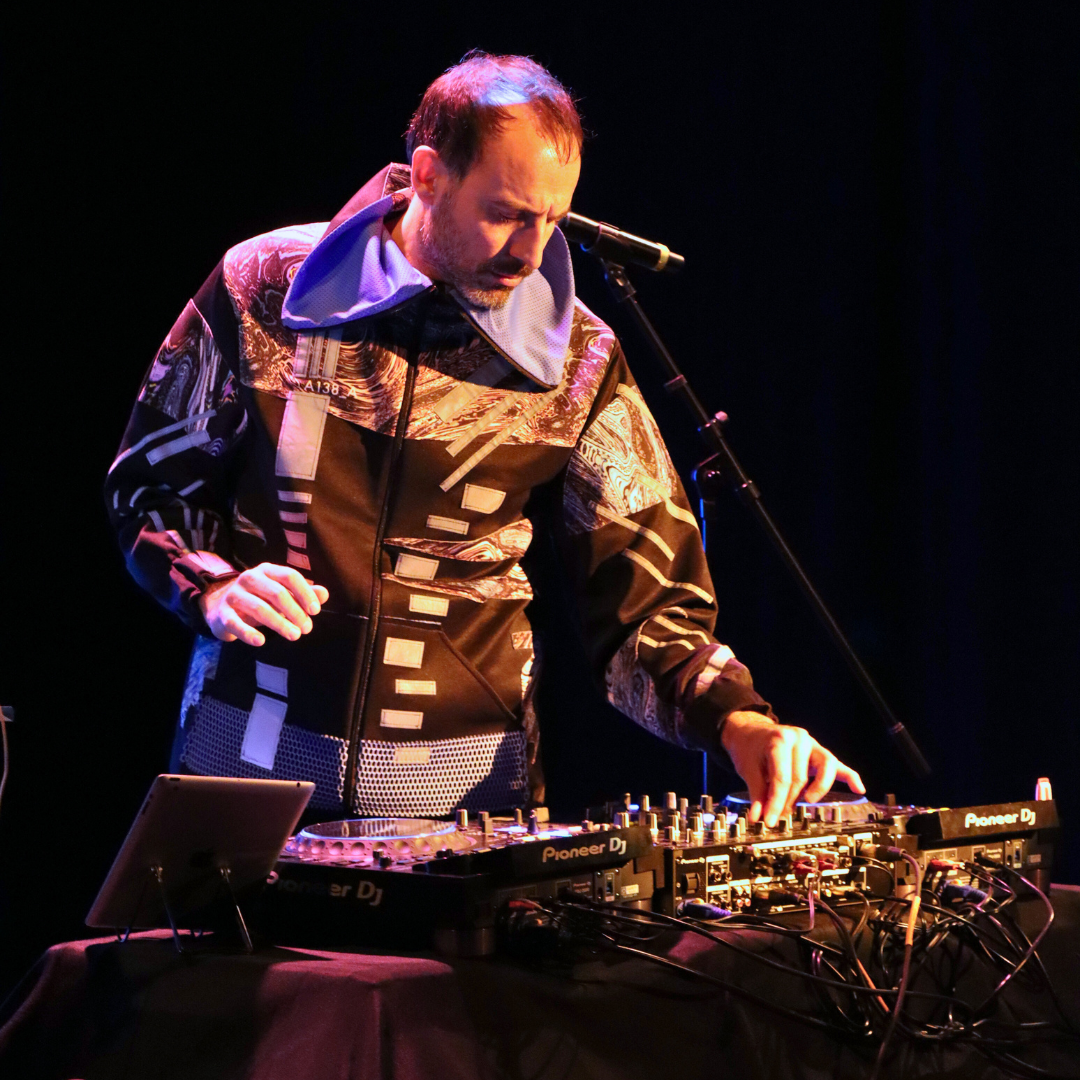 Marcos performing on stage, making adjustments on his dj table 