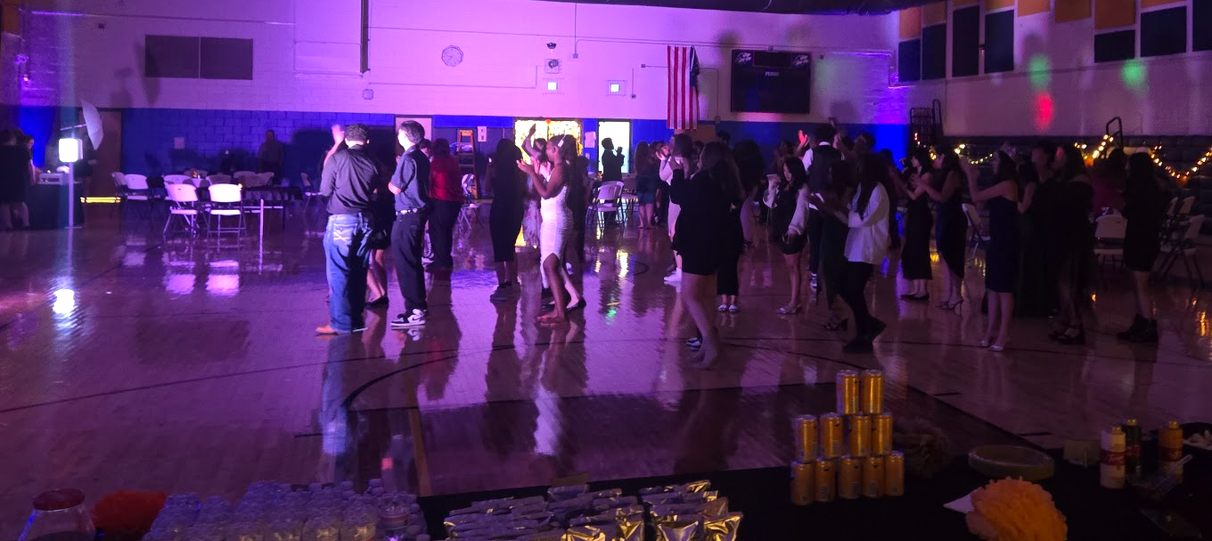Students dancing in a dark gym at homecoming