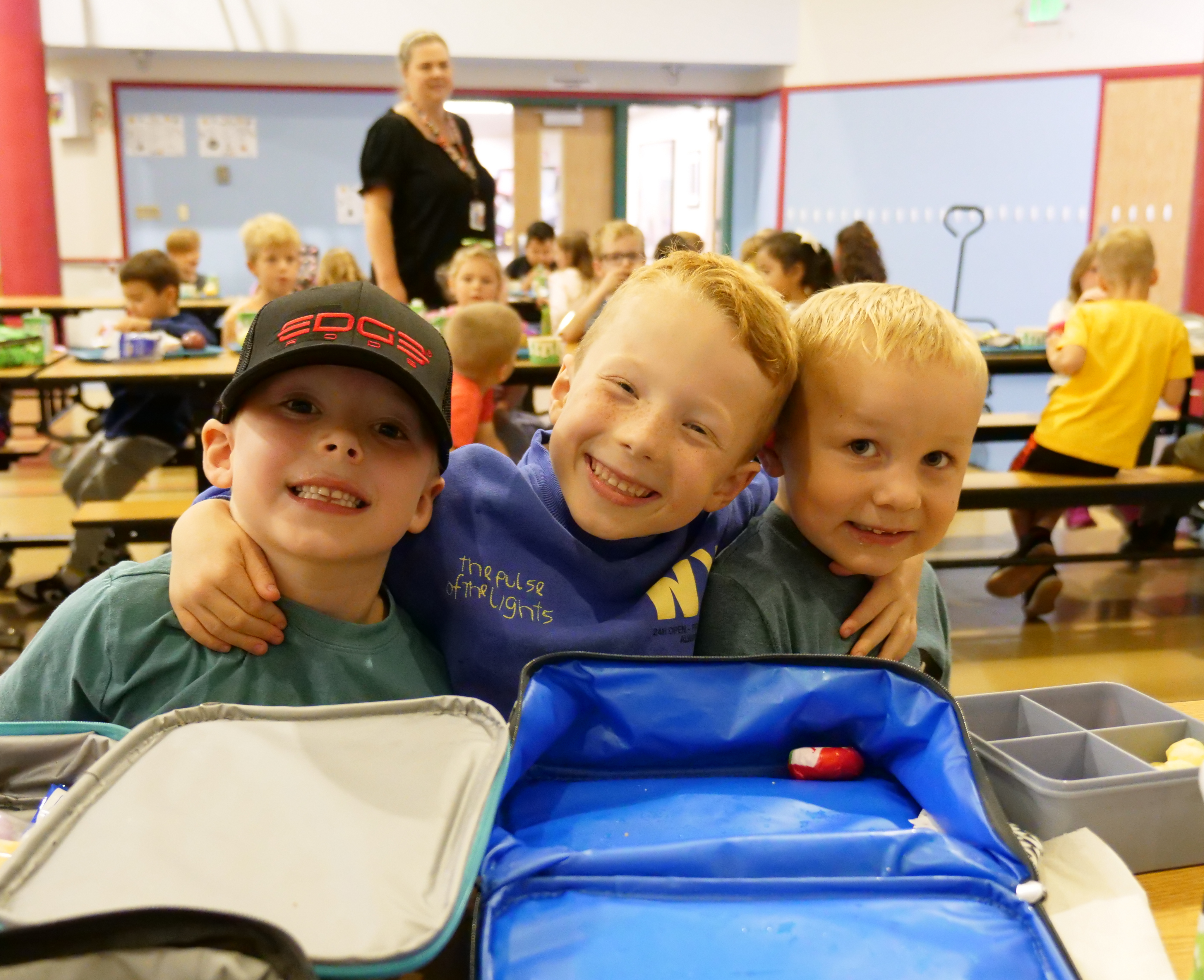 Three students posing for a photo at the lunch table