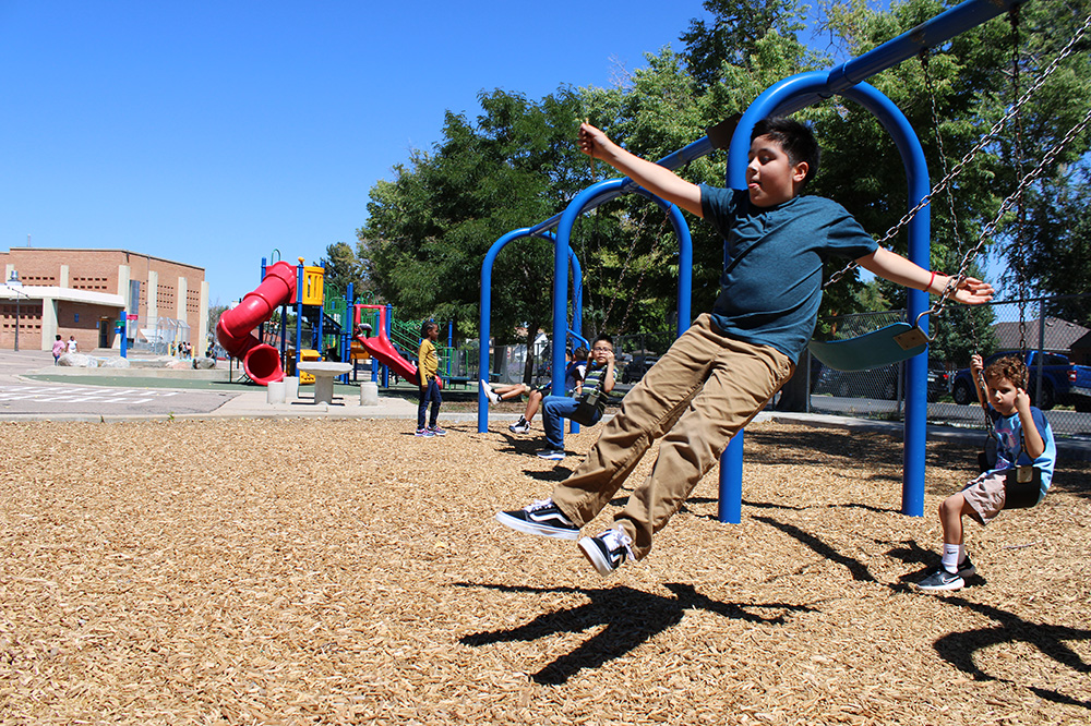 student jumping off a swing