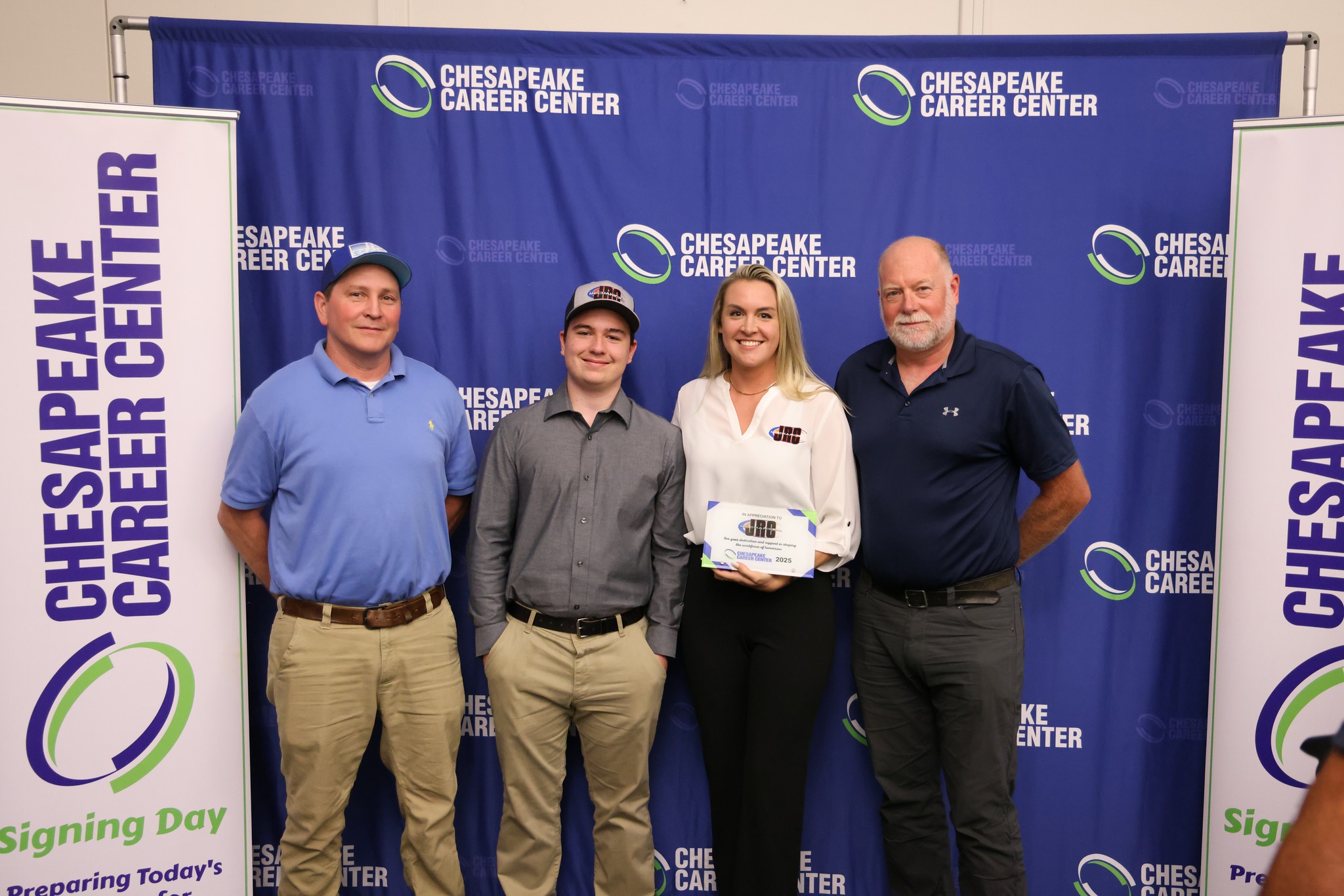 Student smiling with future employers at the Chesapeaek Career Center Signing Day.