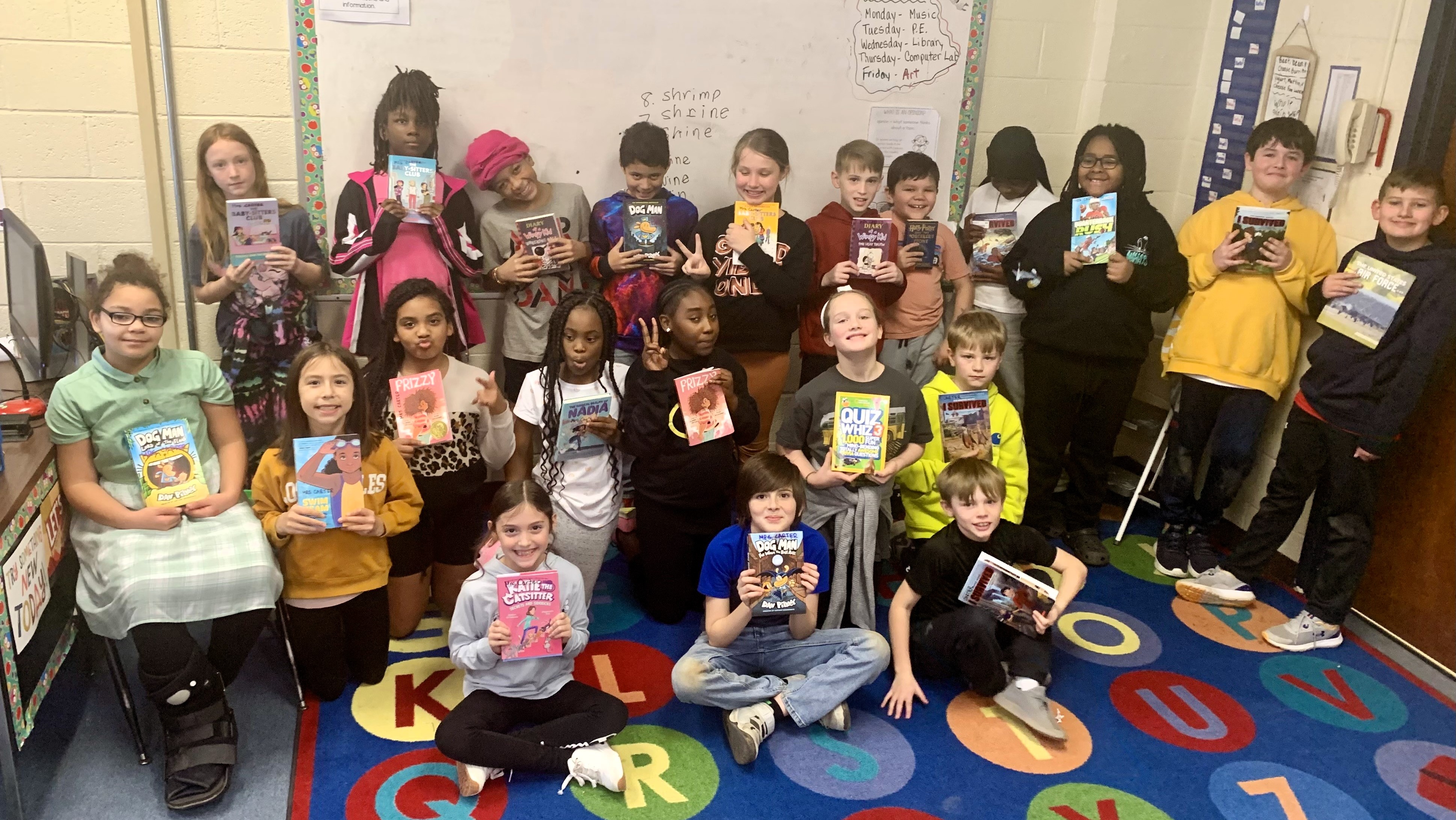 Carter's Class holding up books from their new class library.