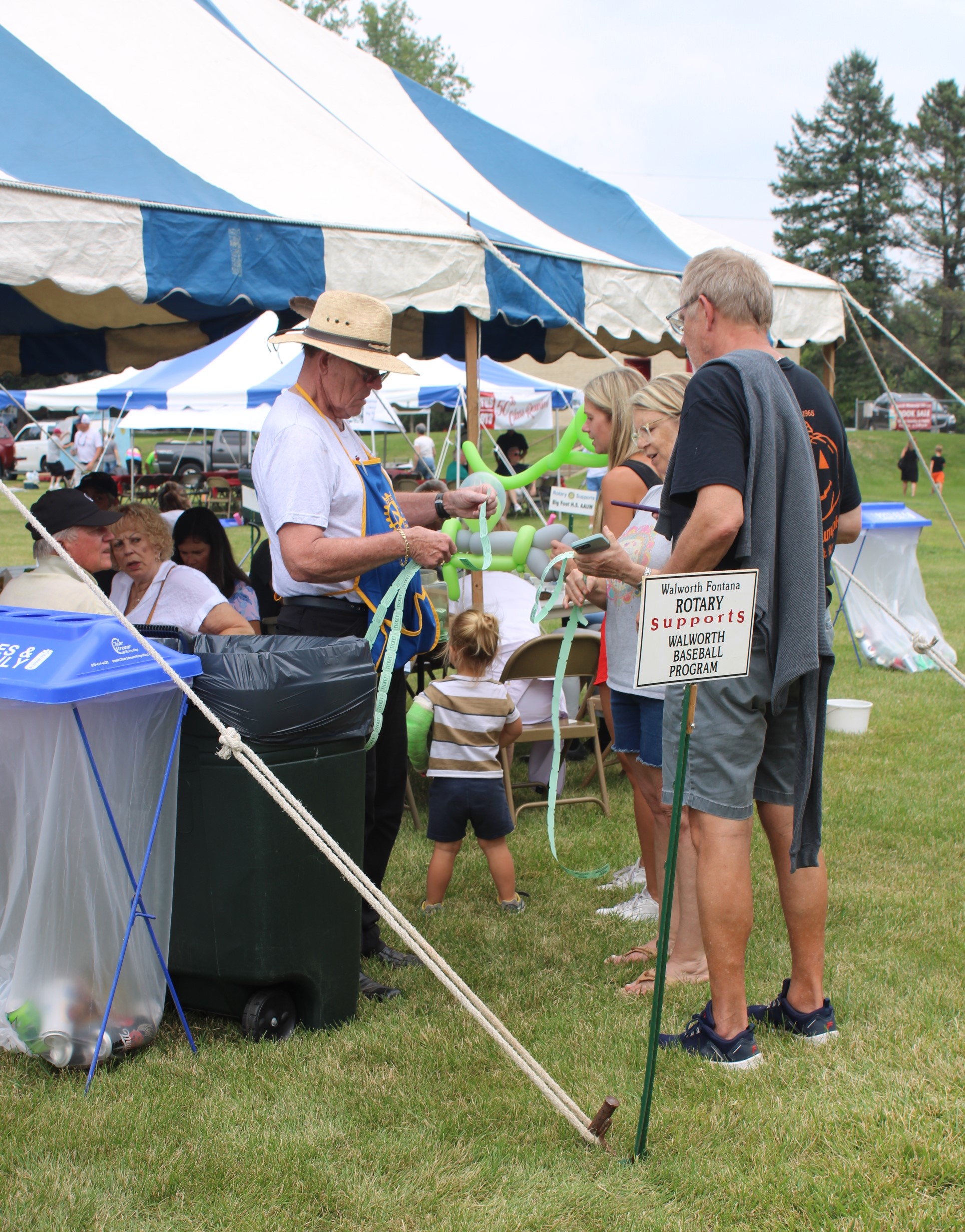 Attendees purchase 50/50 raffle tickets from Rotarian Toby Steivang at the Annual Rotary Corn and Brat Festival Photo by Penny Gruetzmacher