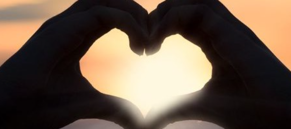 silhouette of hands creating a heart