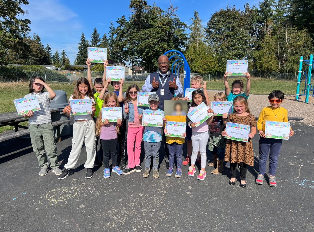 Dr. Carey smiling with Westwood students as they hold up their certificates for summer awards