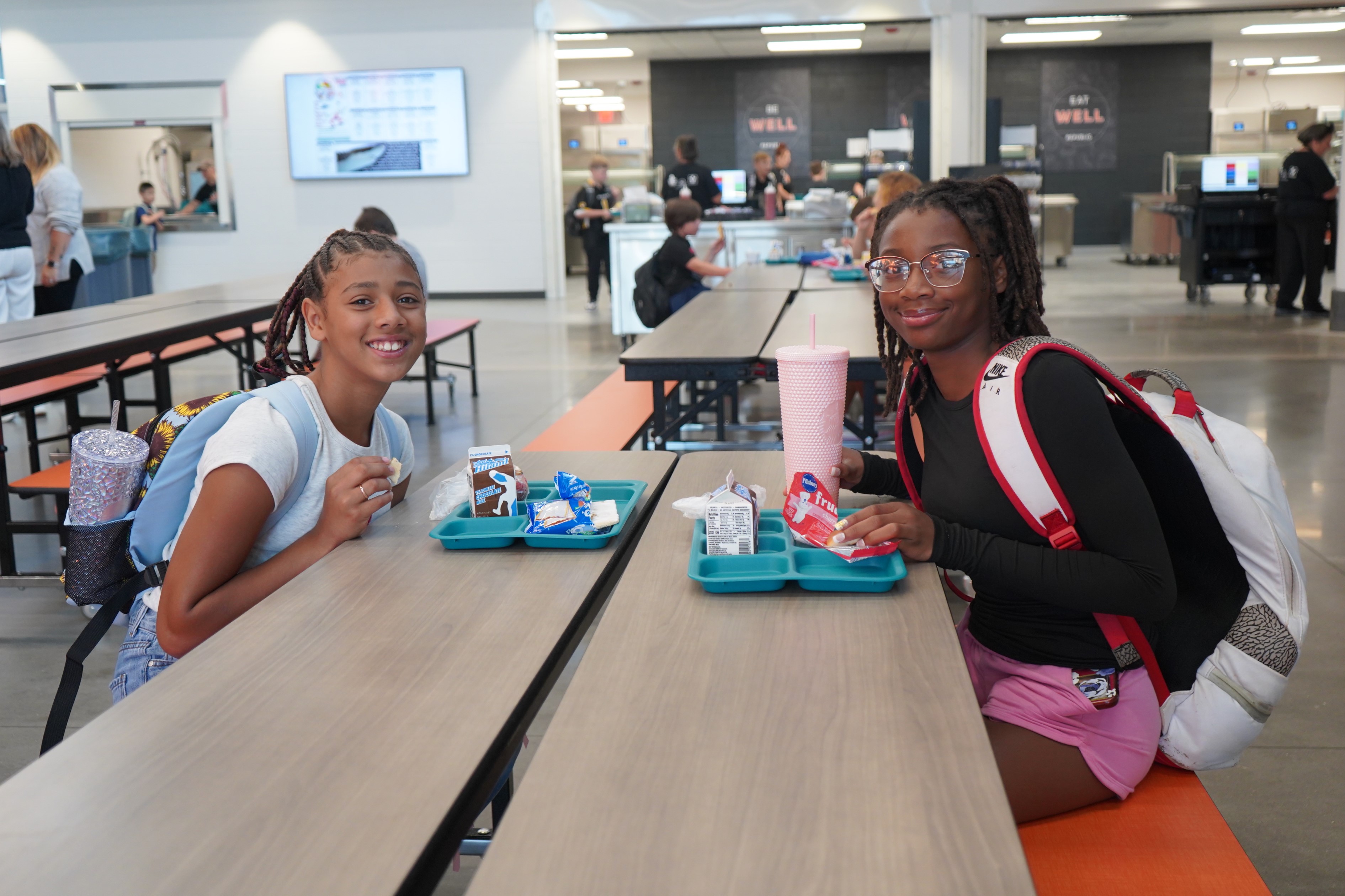 Students smiling while eating breakfast