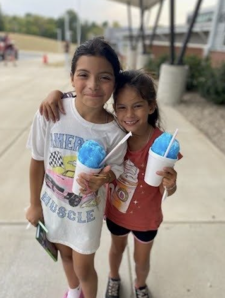 two students smiling with blue snowcones