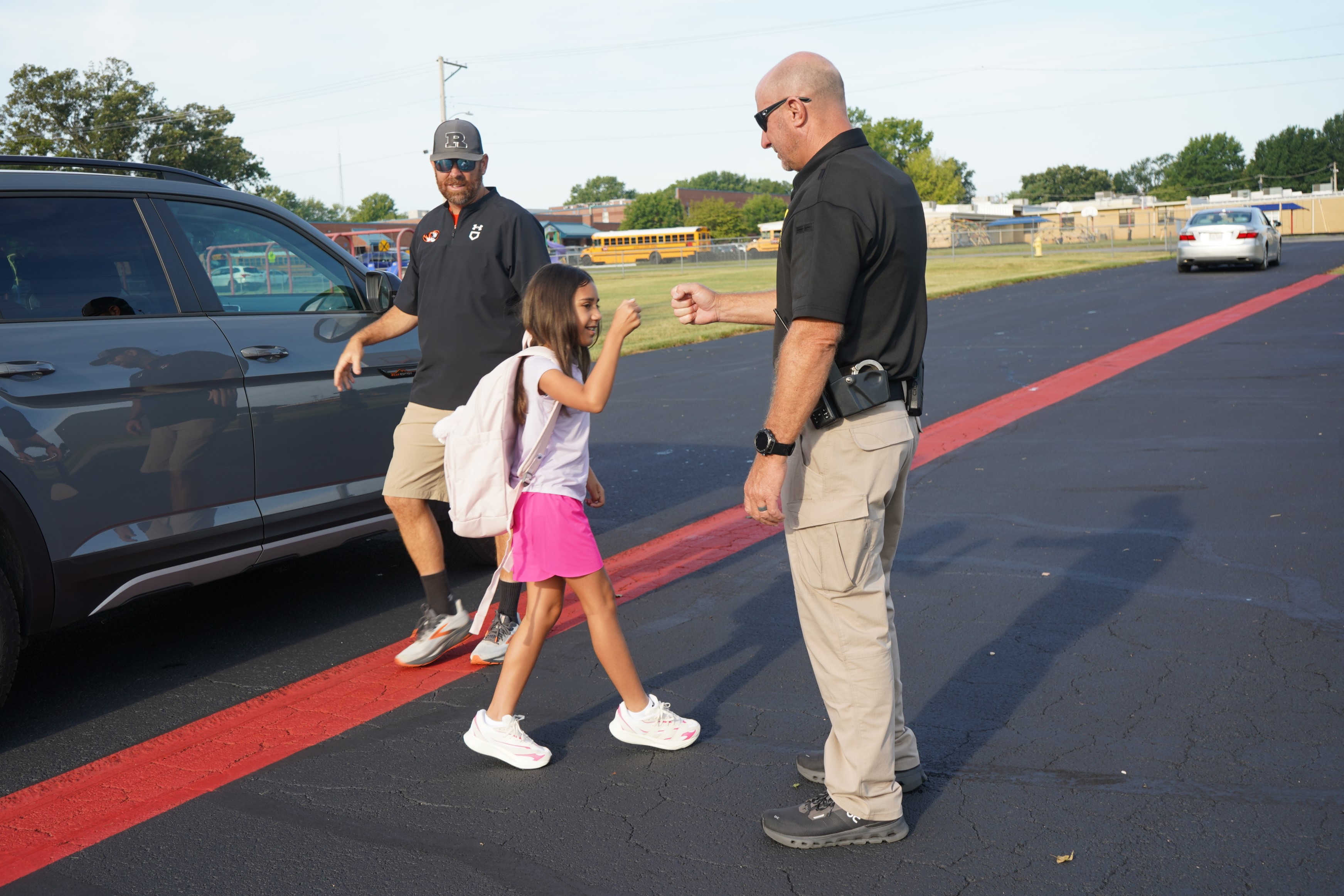 Student giving a fist bump to a school resource officer