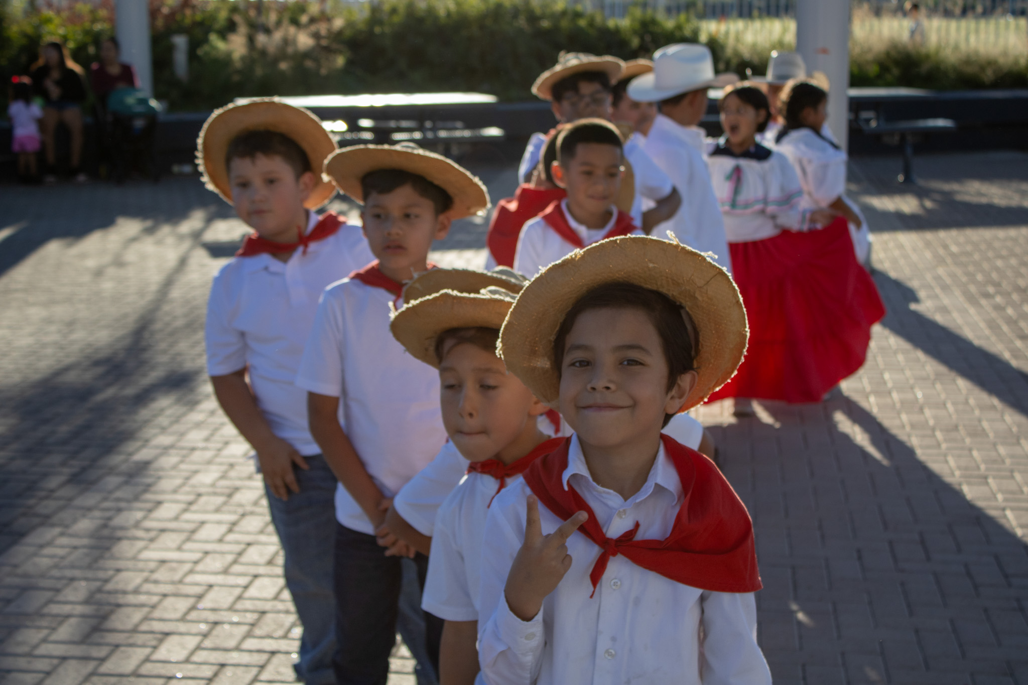 A student flashes a peace sign at the camera before his Fiesta Hispana performance. 