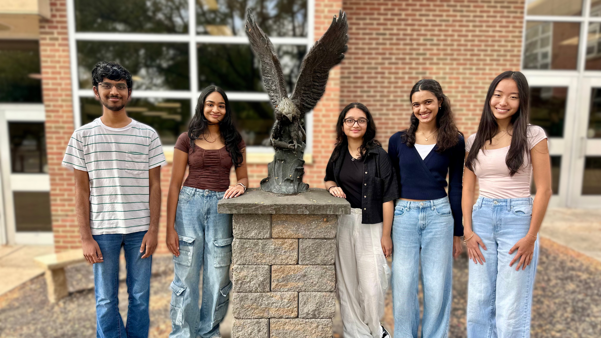 Five CVHS students named 2026 National Merit Scholarship Semifinalists standing by an eagle statue.