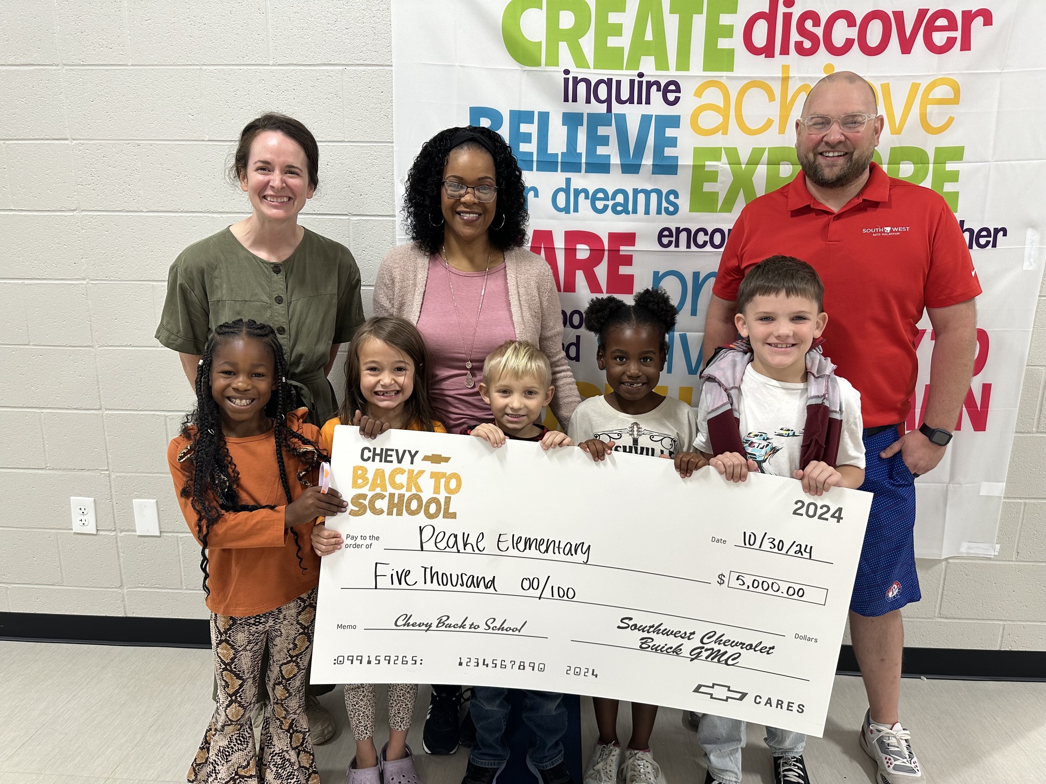 students parents principal and SW rep holding check