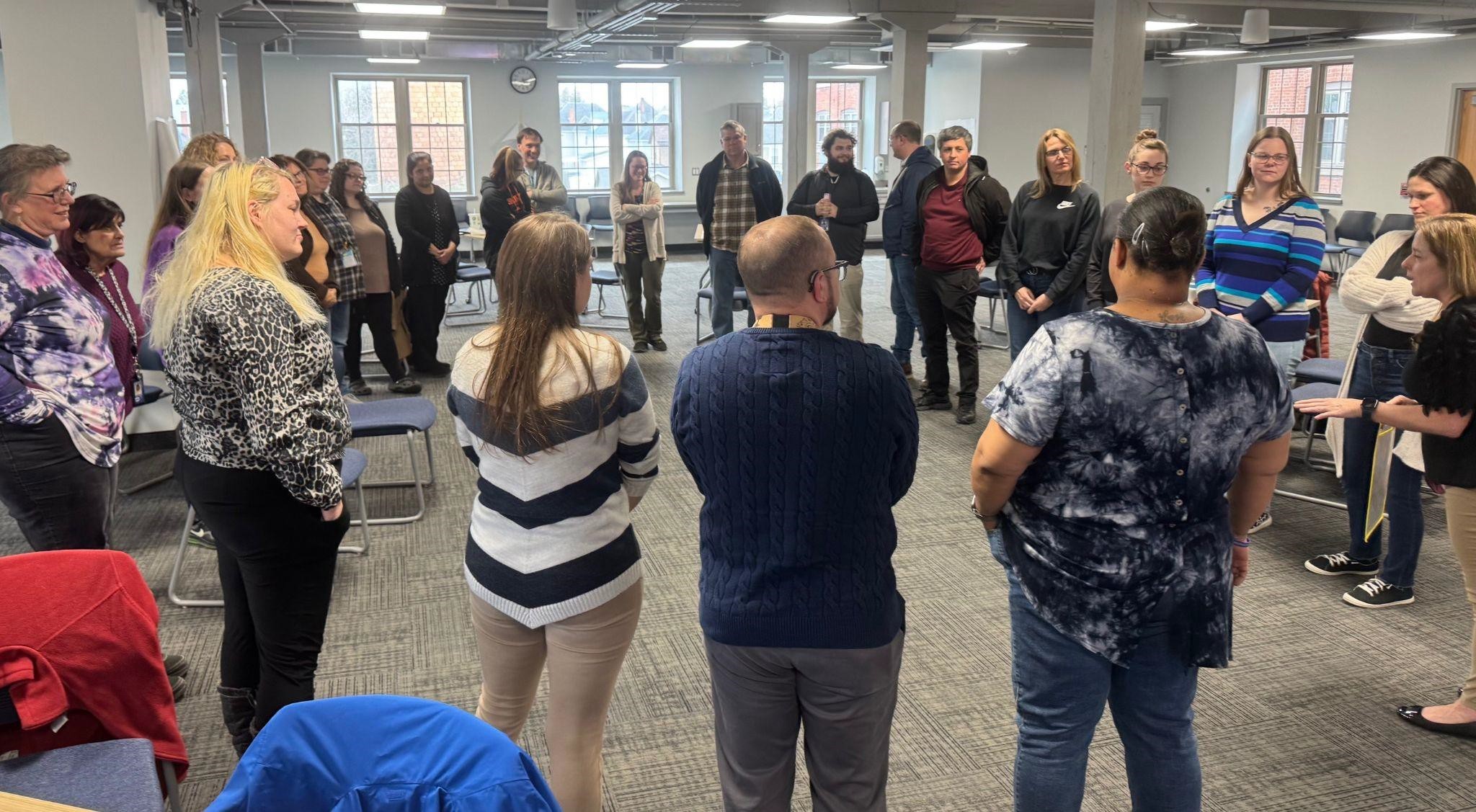Many staff members in a large circle for a training