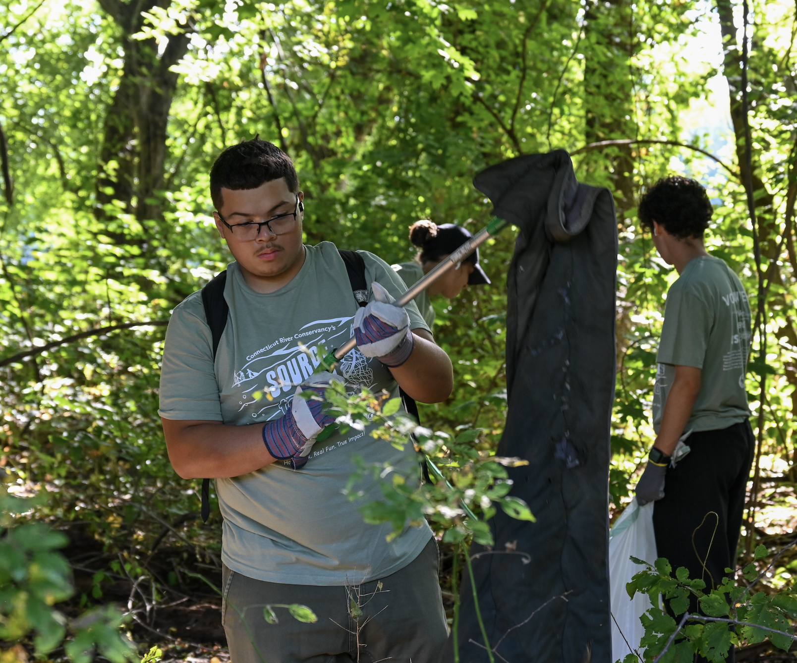 Student picks up textile waste with garbage picker