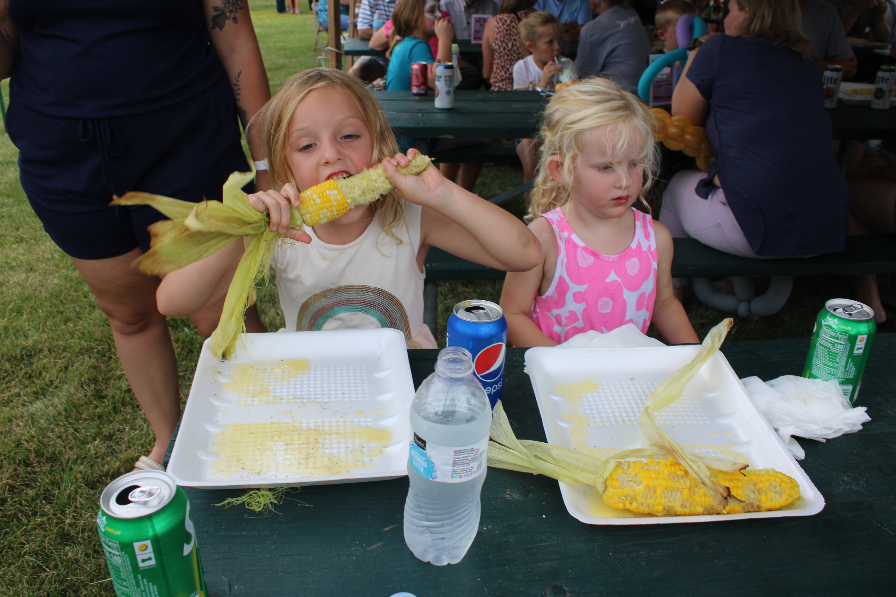 Two young children enjoy corn on the cob at the annual Rotary Corn and Brat Festival Photo by Penny Gruetzmache