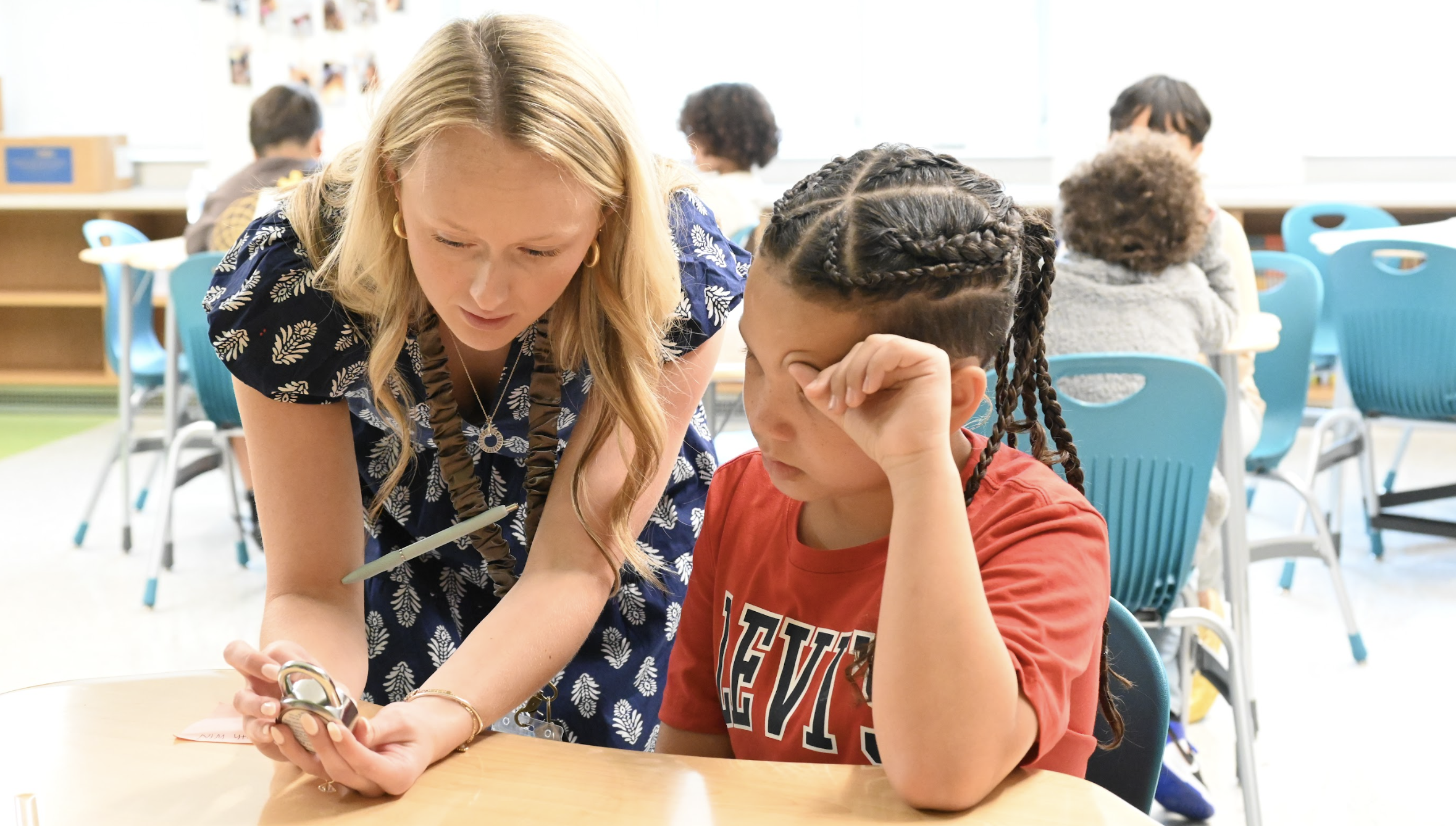 A student and teacher look at a combination lock