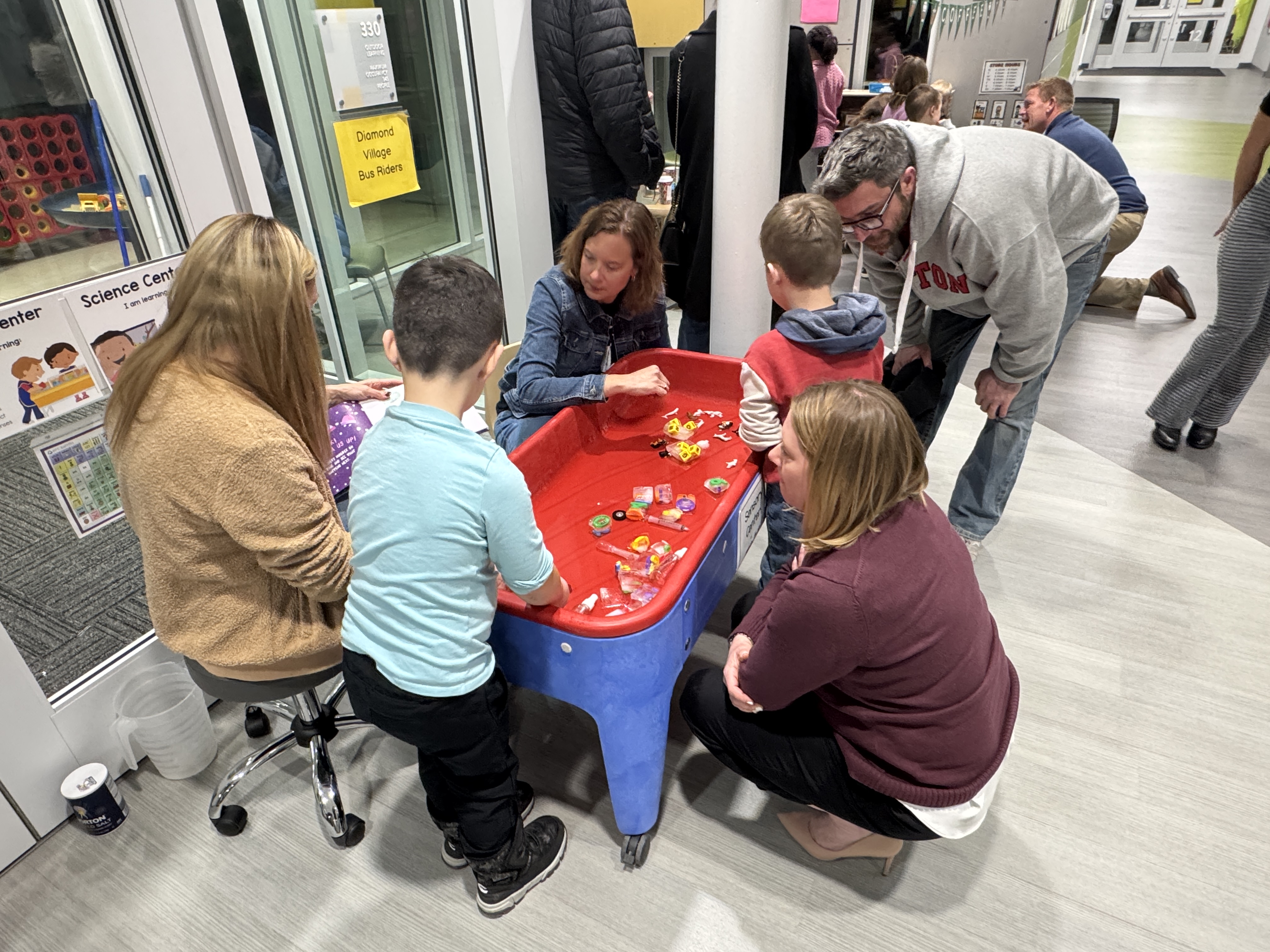 adults and children using a sensory table
