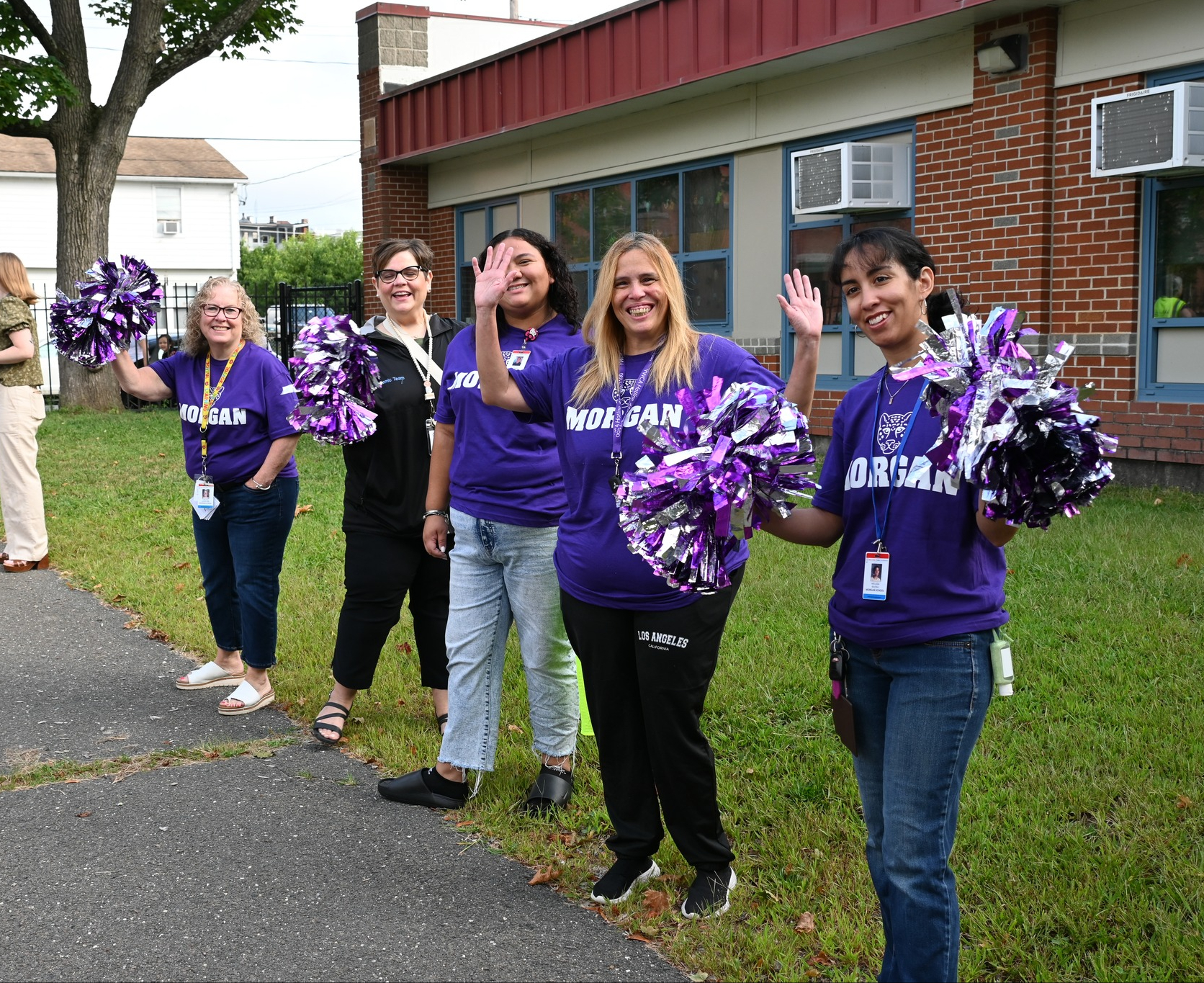 Morgan School staff cheer for new students arriving