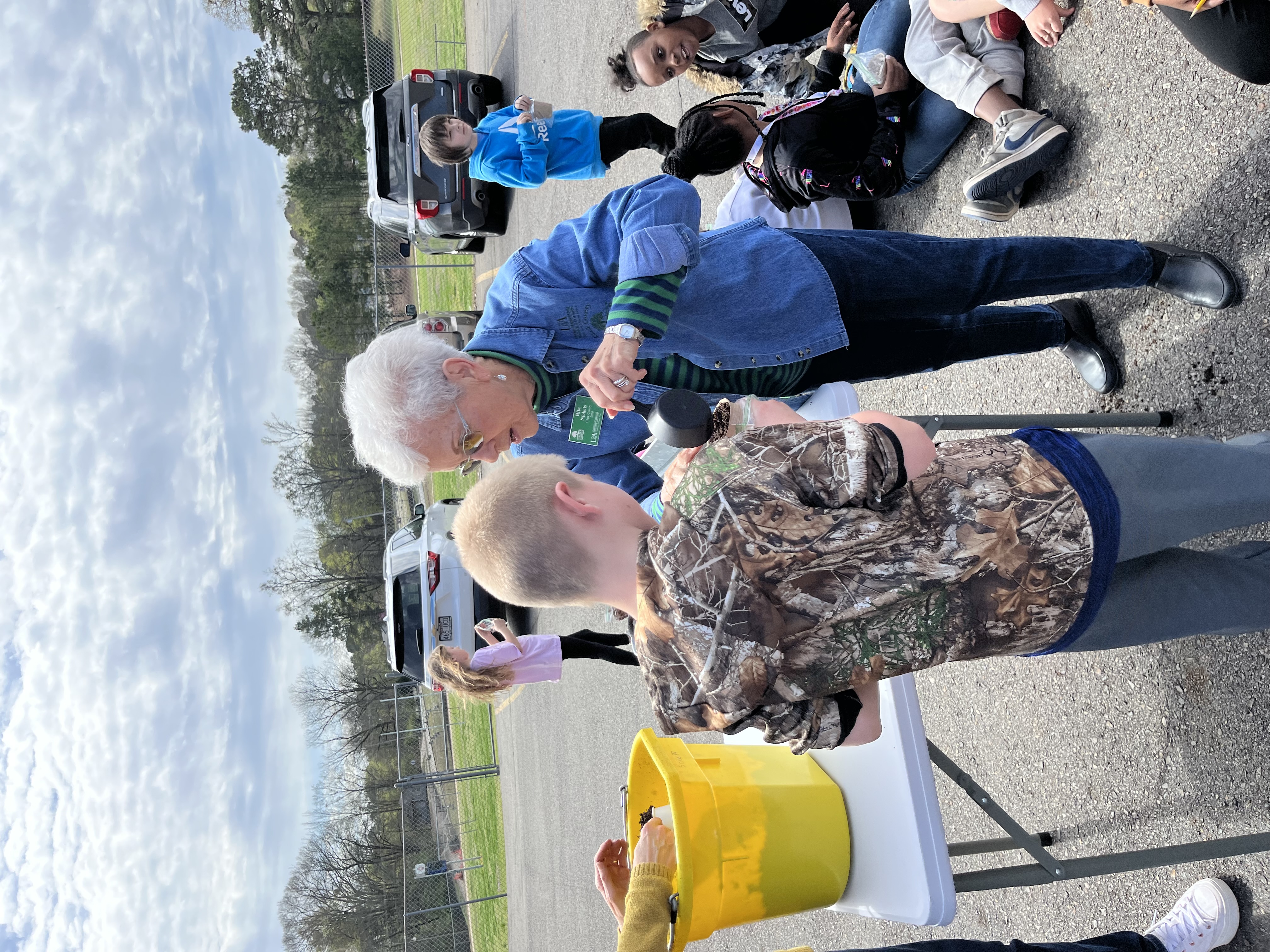 Master Gardeners helping students plant seeds