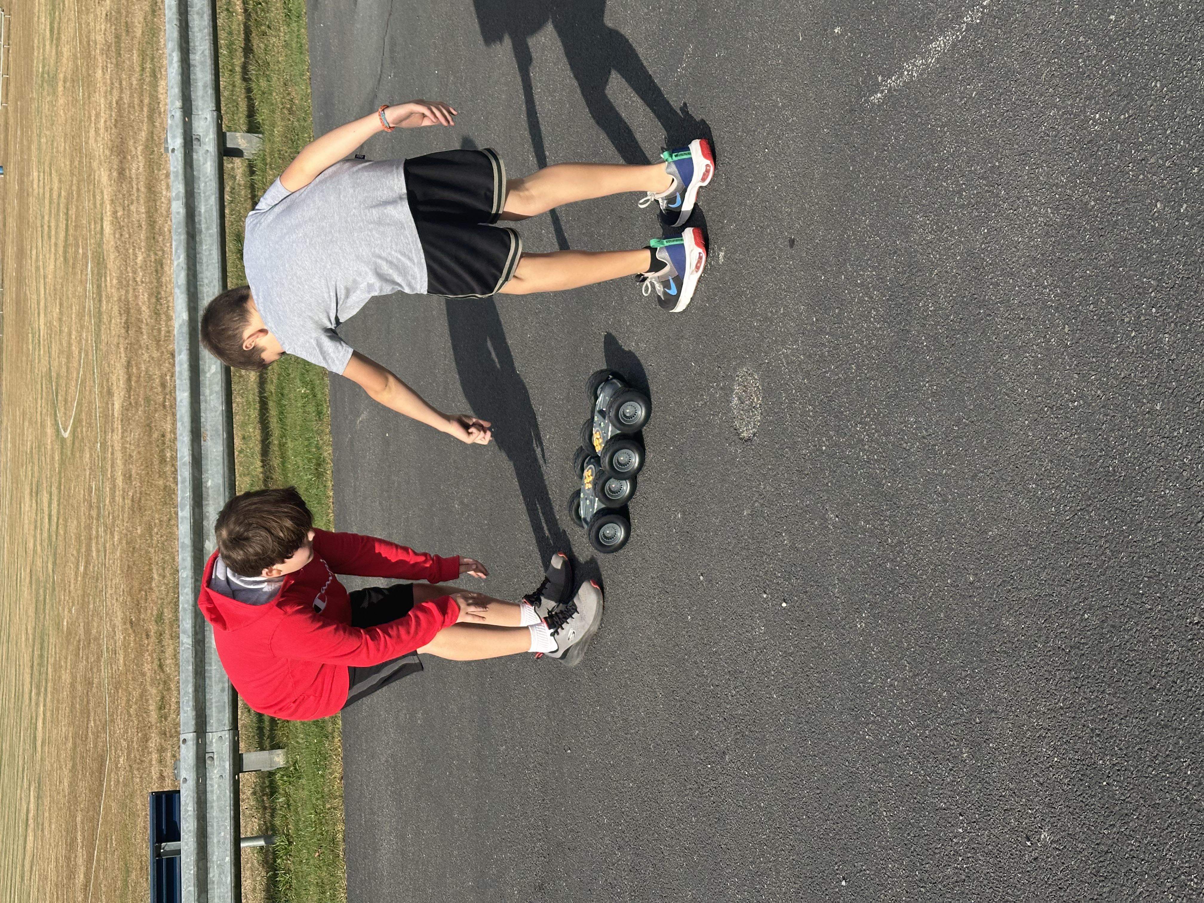 Two boys working with robots outside