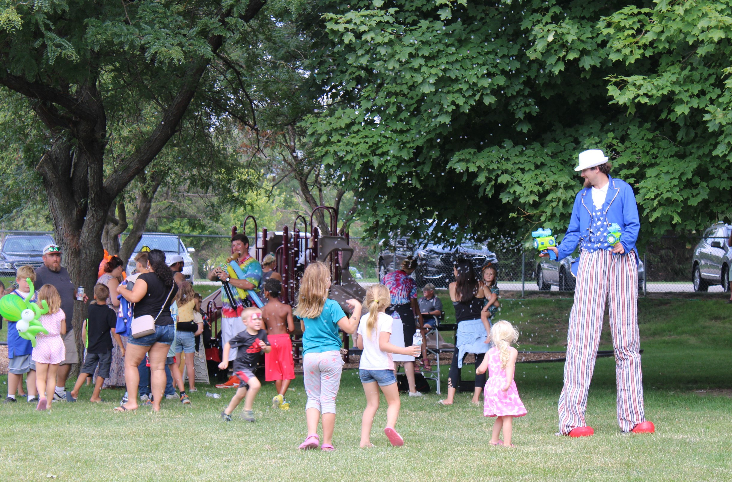 Children and adults gather in the park as performers entertain Photo by Penny Gruetzmacher