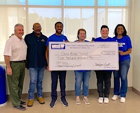 people smiling holding a 3000 dollar check