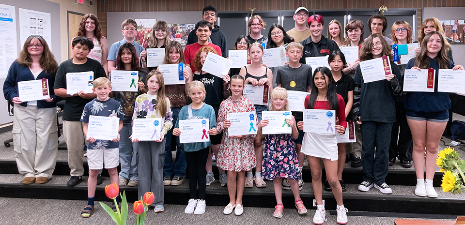 A group of students holding art show winner certificates