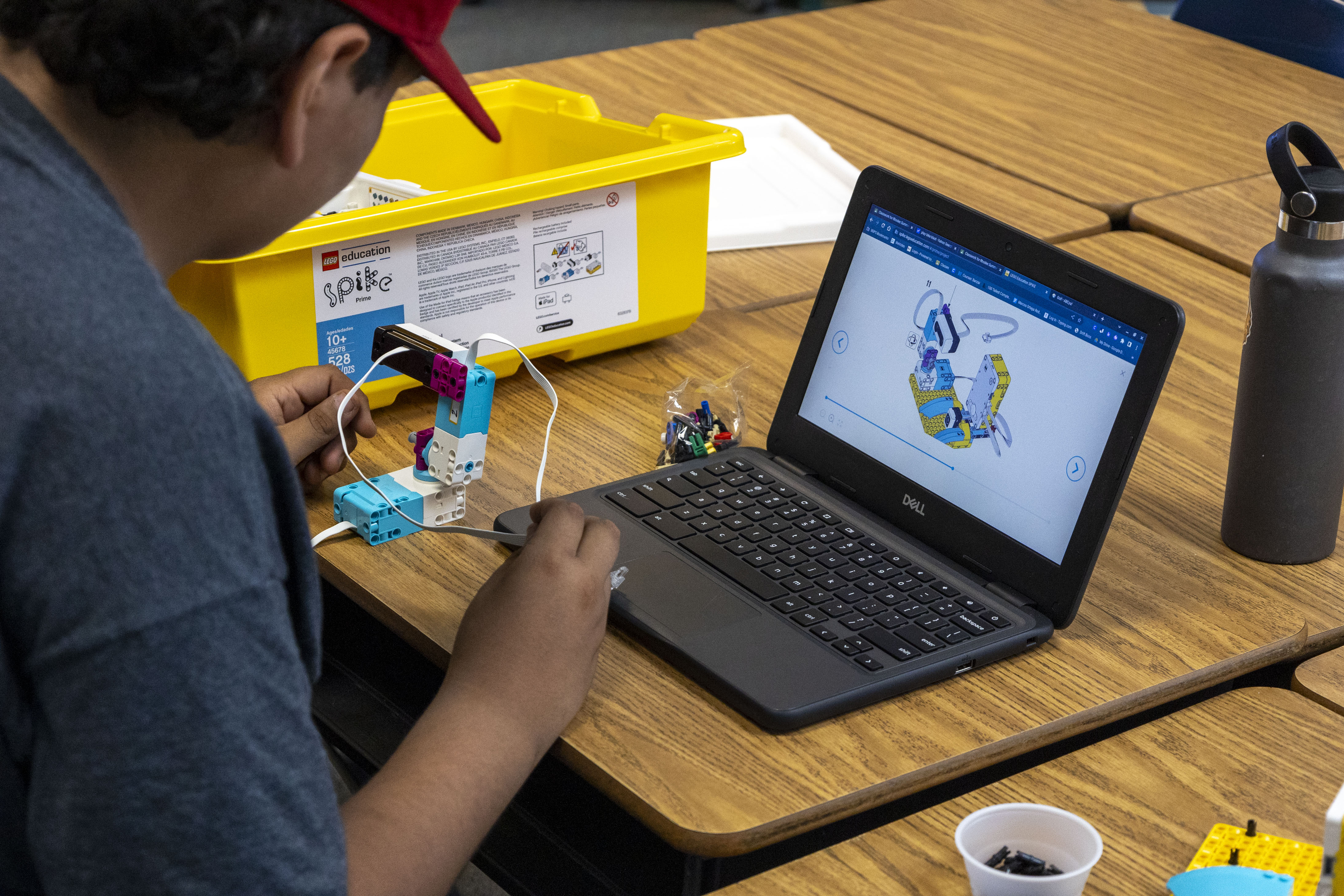 A child programming a LEGO creation on a computer