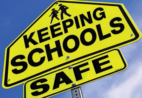 Road sign with 2 figures walking with the words "keeping school safe."
