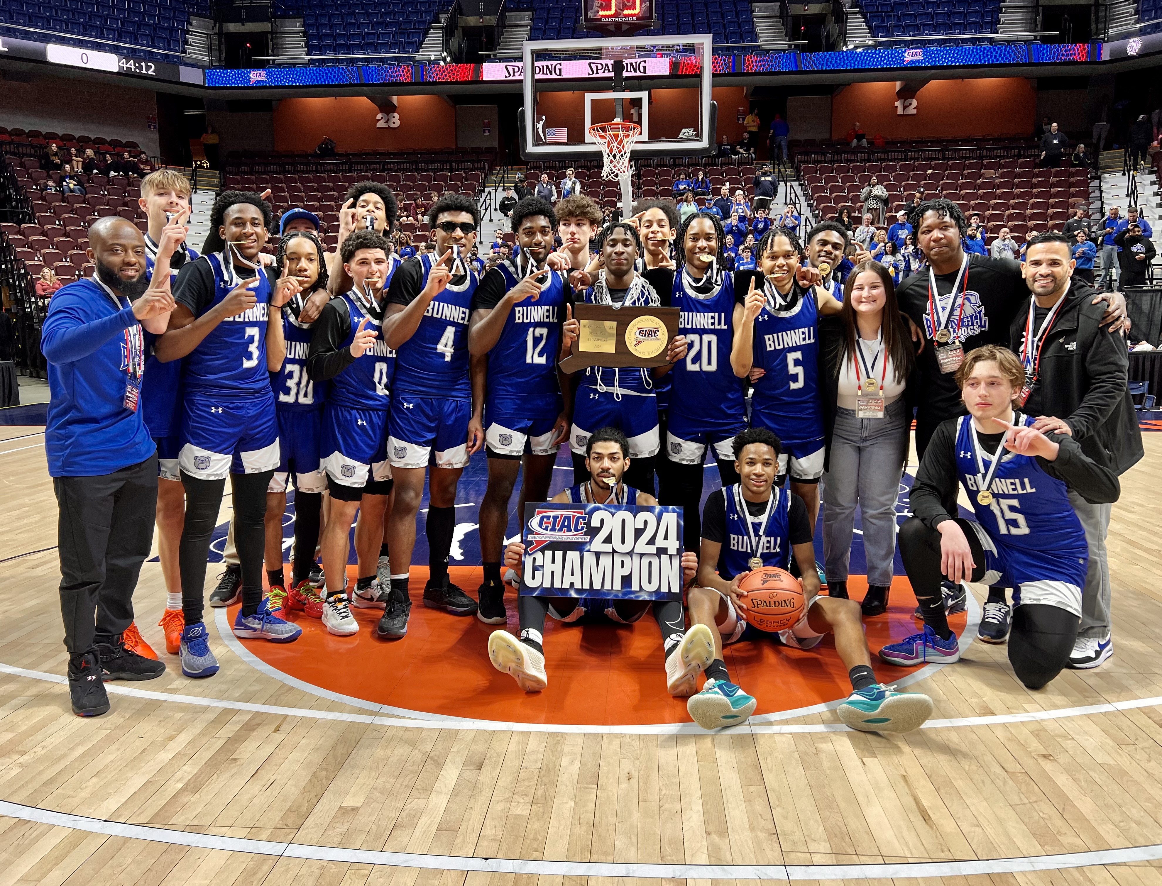 basketball students standing with trophy