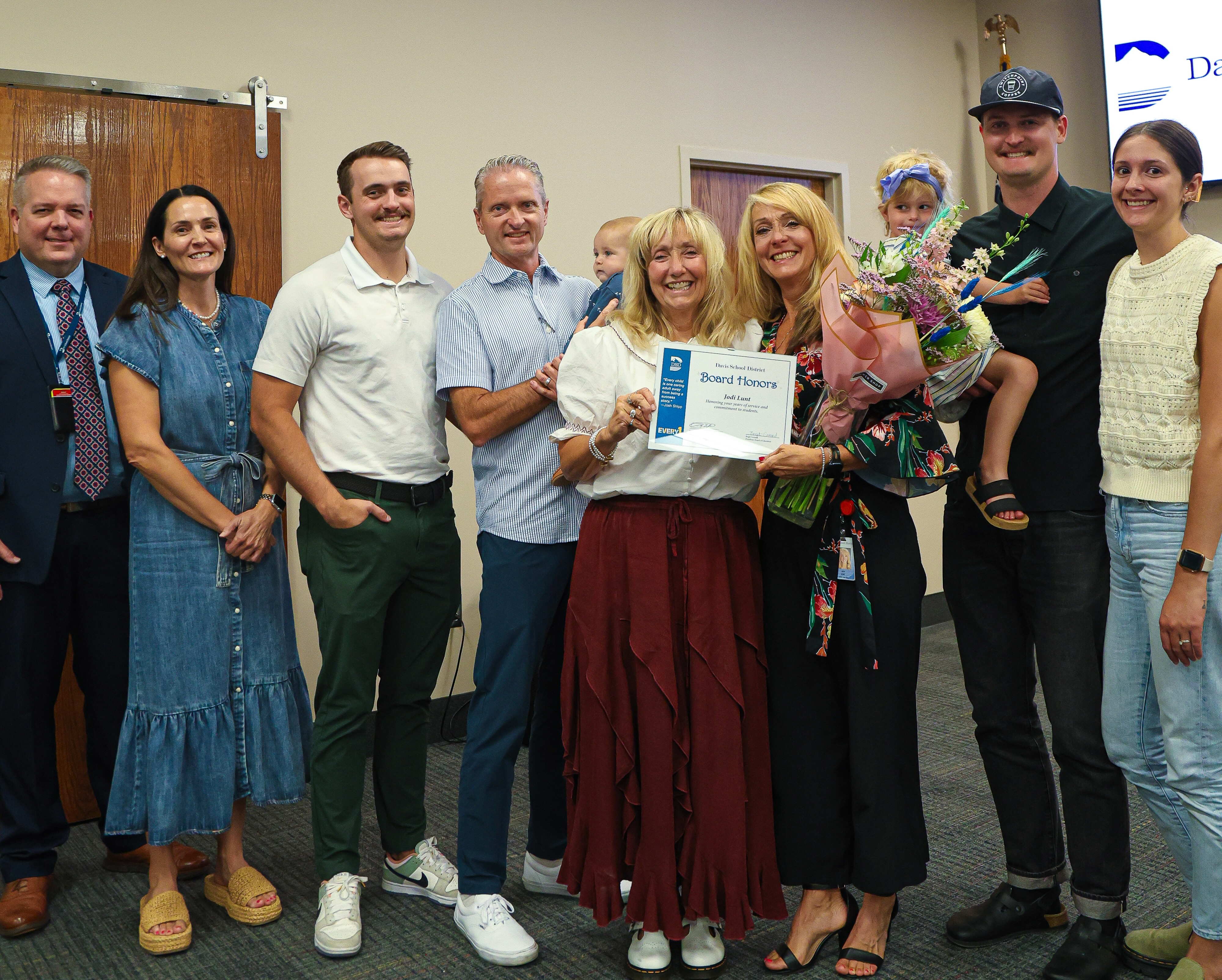Board members, superintendent and Ms. Jodi Lunt and family post with certificate during board honors