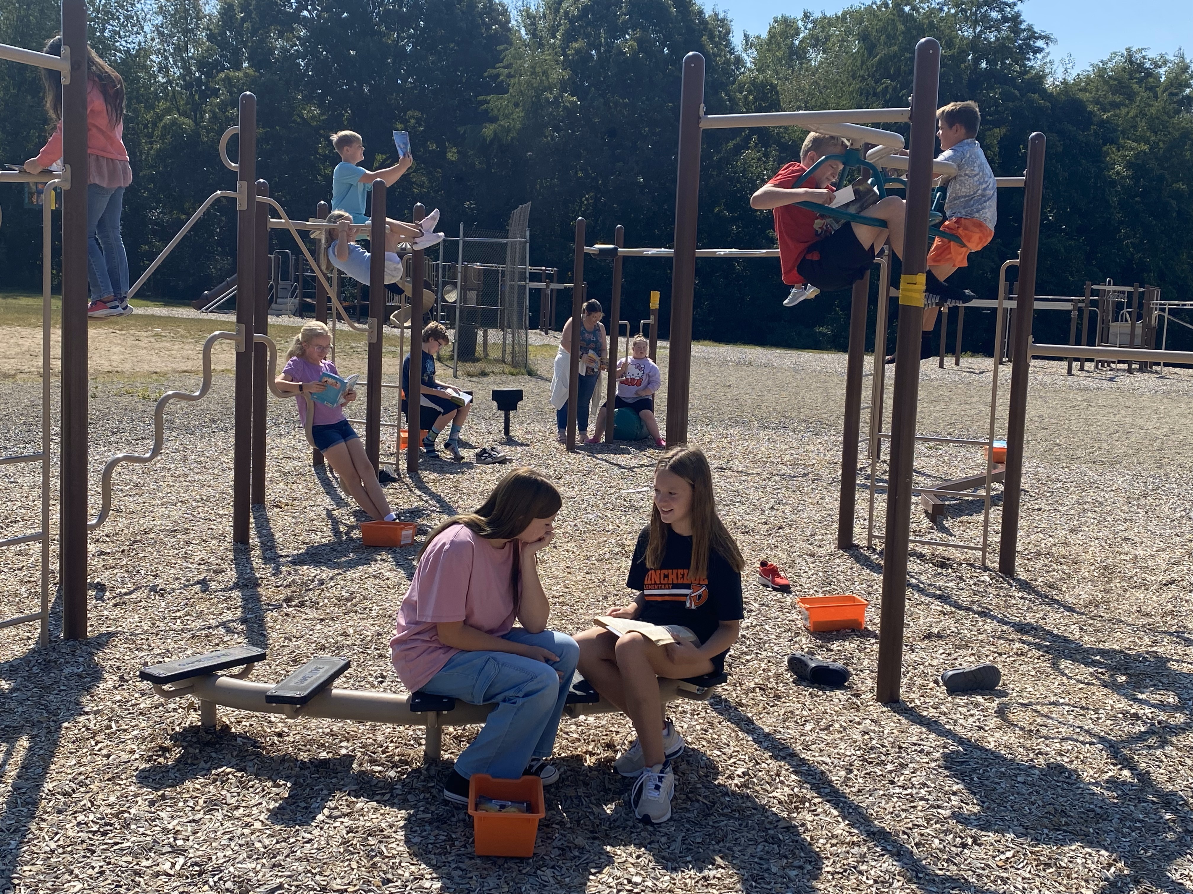 Mrs. Mroczek's class enjoying reading time outside on the playground.