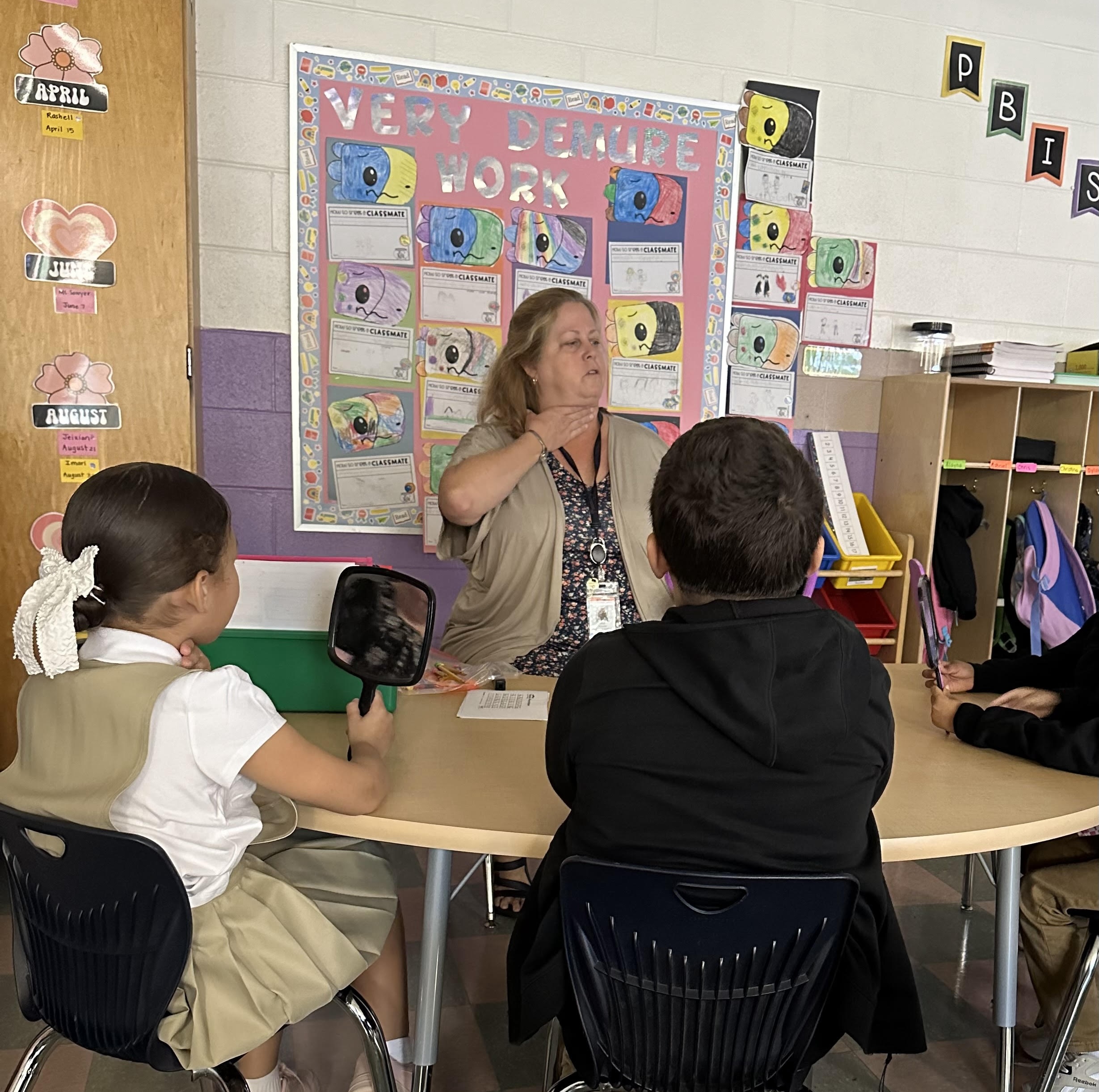 Educator teaches students to make vowel sounds