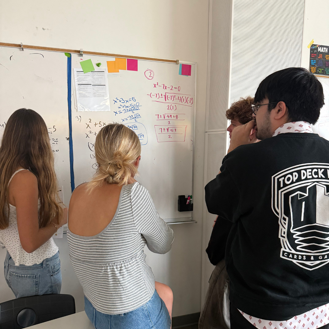 Three high school students solving algebra together.