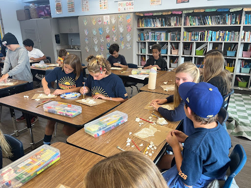 Students work together on a hands-on classroom project using building materials.