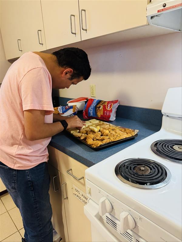 Tristin making sure everything is aligned and ready for baking for his meal plan. (Chicken tenders dipped in homemade orange sauce, with veggie spring rolls and sticky rice!)