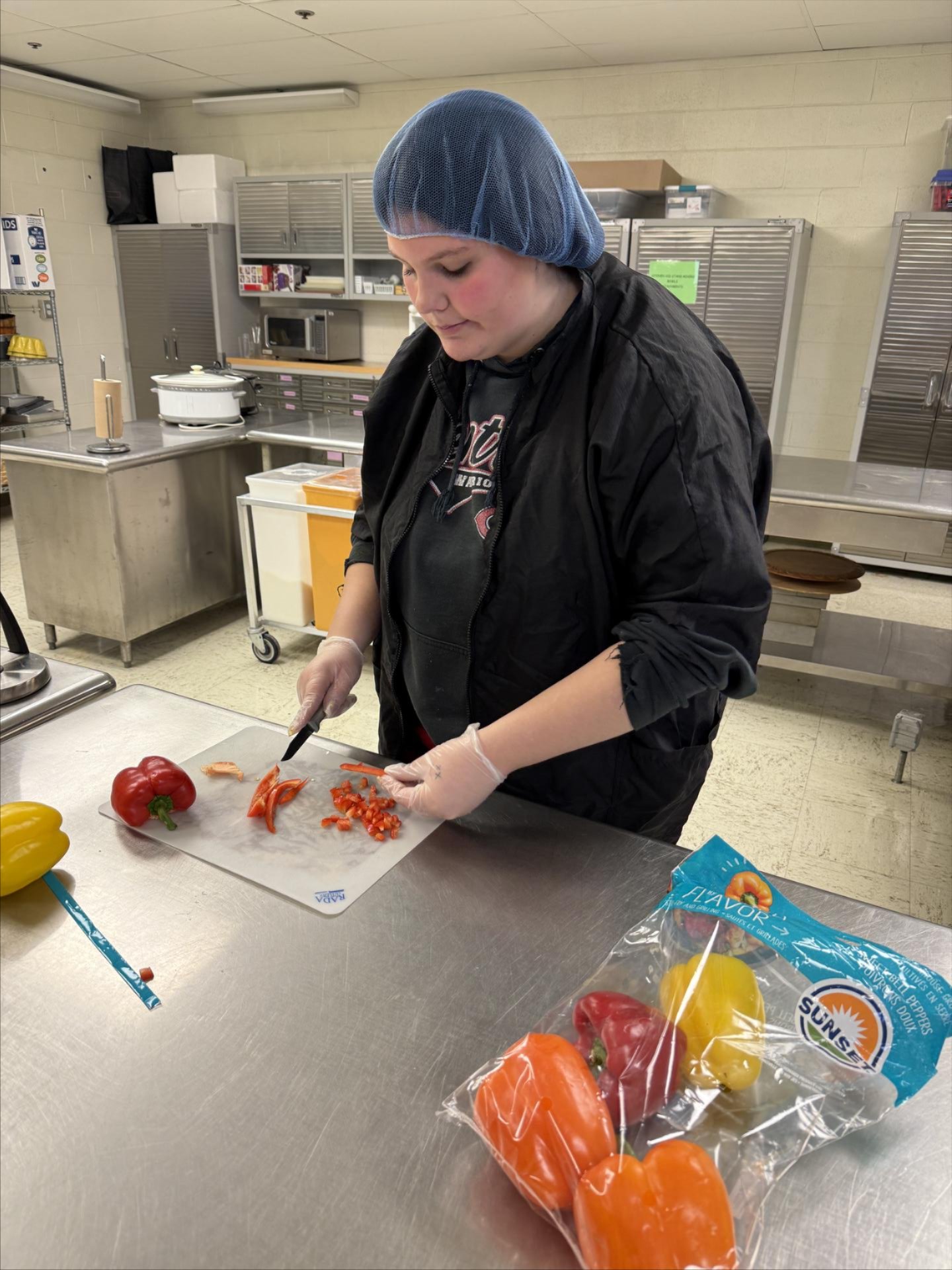 A student chops peppers
