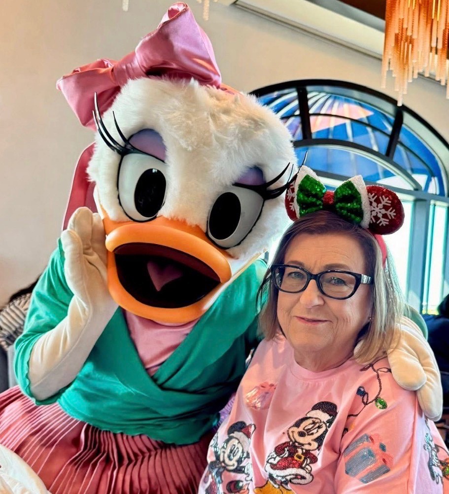 Mrs. Dotson stands with a Disney character