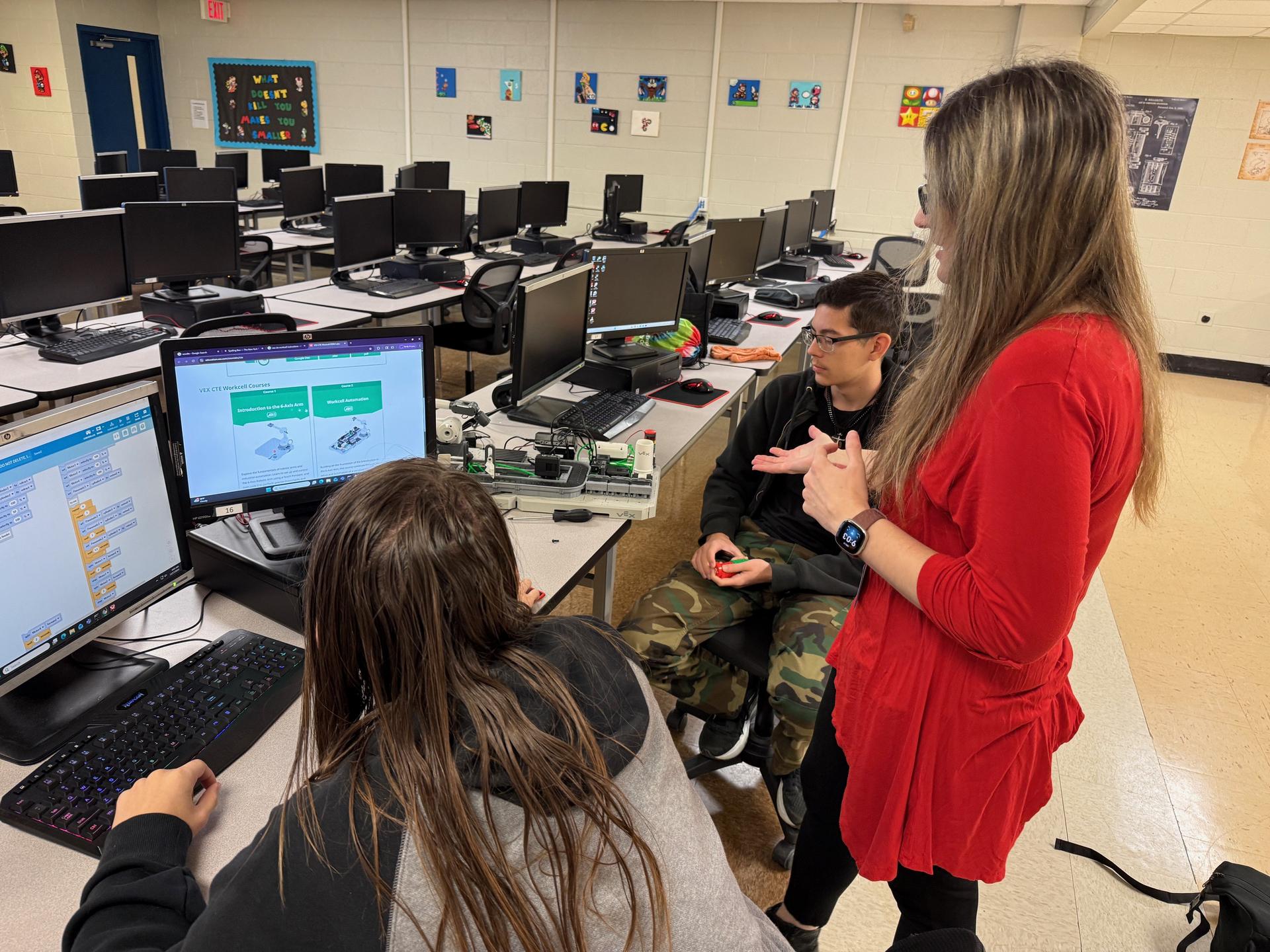 Mrs. Lawson works with IT students on a distribution prototype
