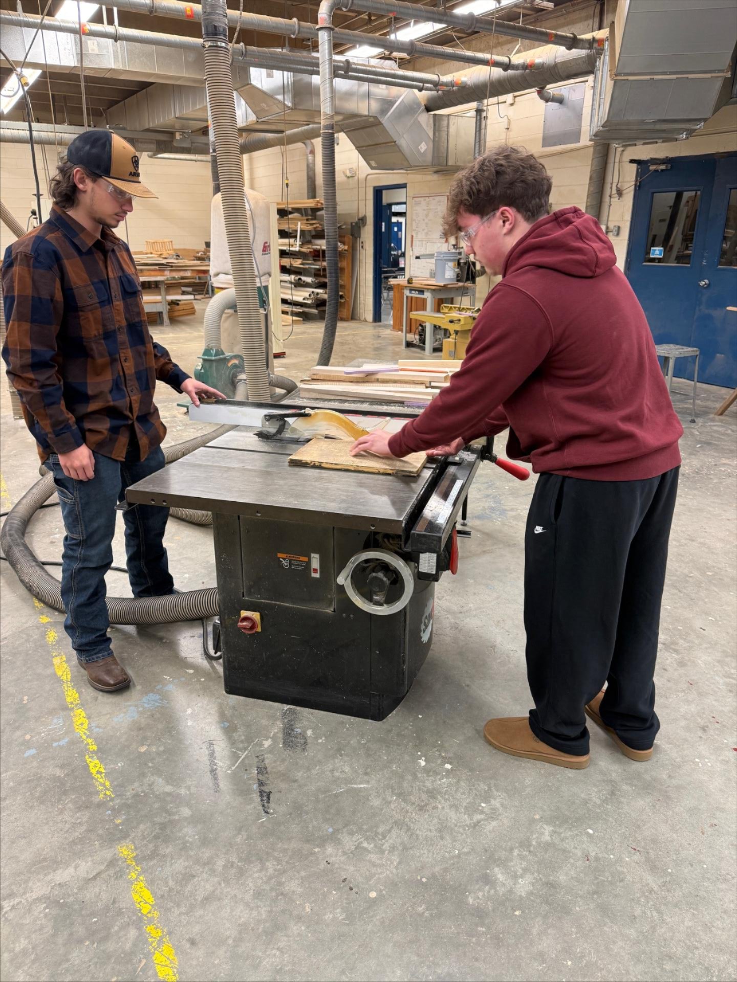 Two male students rip a board