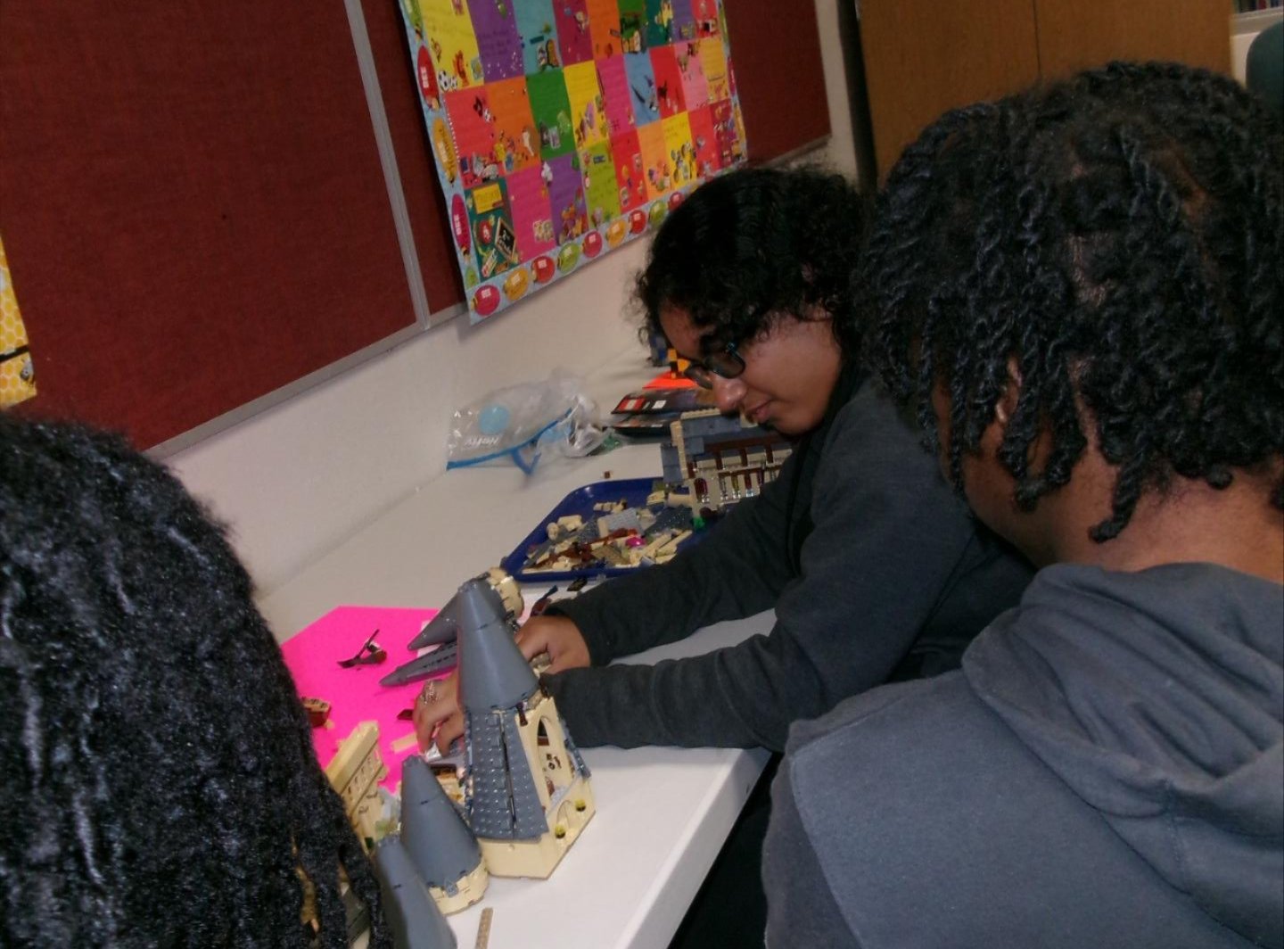 Alina works on a Lego creation while Khau