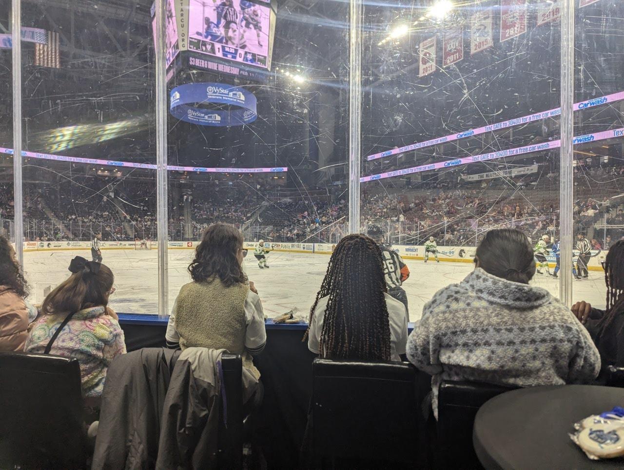 Angie, Serraya, Meadow, and McKenzie sitting at the glass watching the game