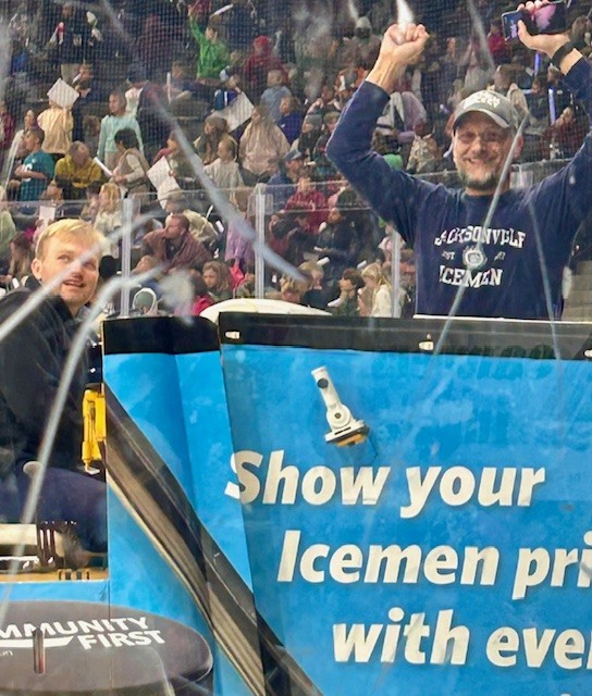 Mr. Cosgrove on the Zamboni with his arms raised in the air