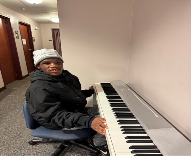 Zach sitting at a digital piano keyboard