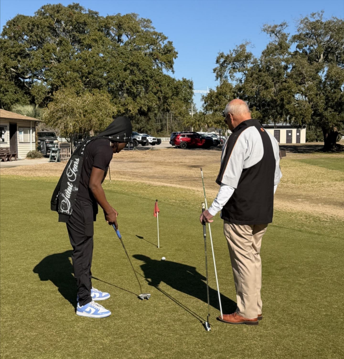 DJ putting while his instructor stands by